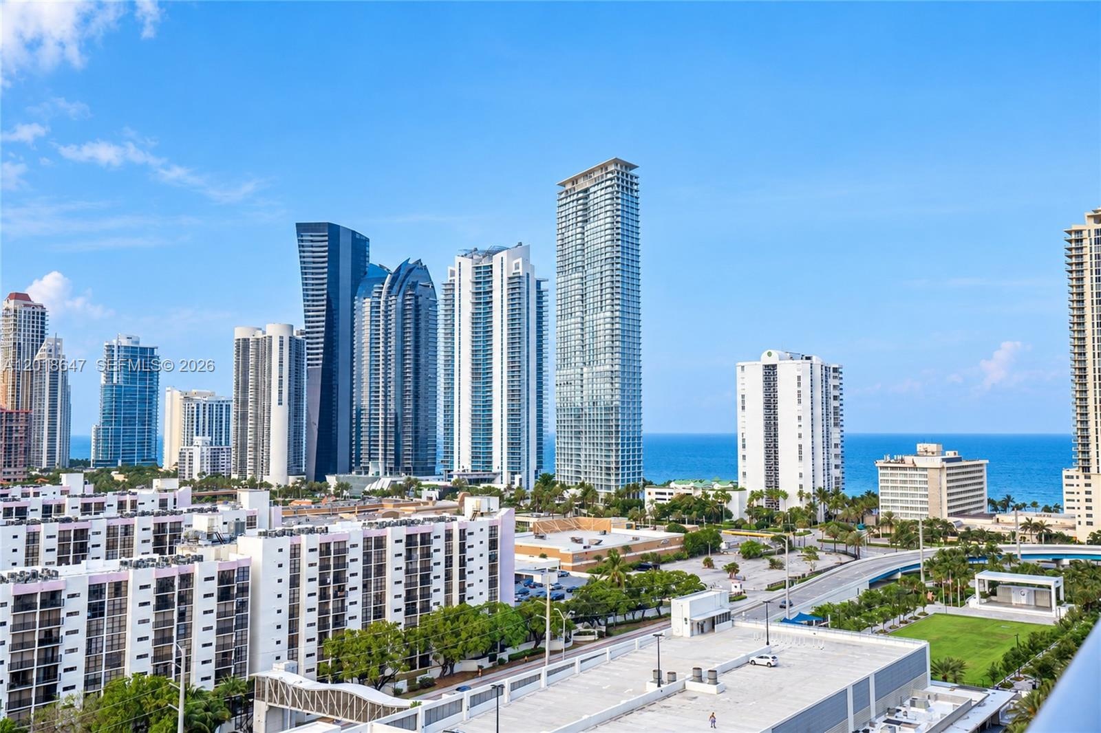 Elevated urban setting featuring high-rise skyline architecture, expansive ocean horizon, and coastal atmosphere