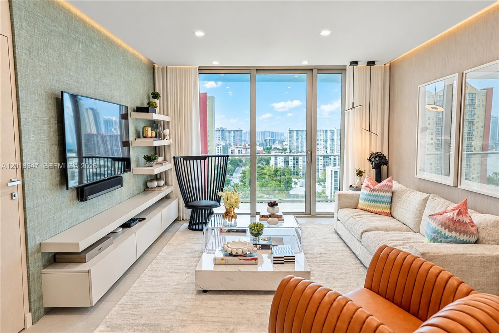 Open-concept interior featuring recessed lighting, a modern branching chandelier, wall-mounted floating media cabinetry with integrated shelving, and 