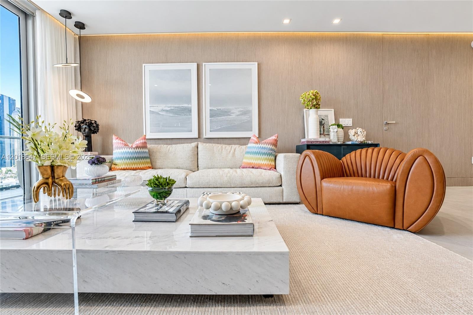 Floor-to-ceiling glass sliding doors, recessed lighting, textured wall paneling, and an expansive balcony with metal railing