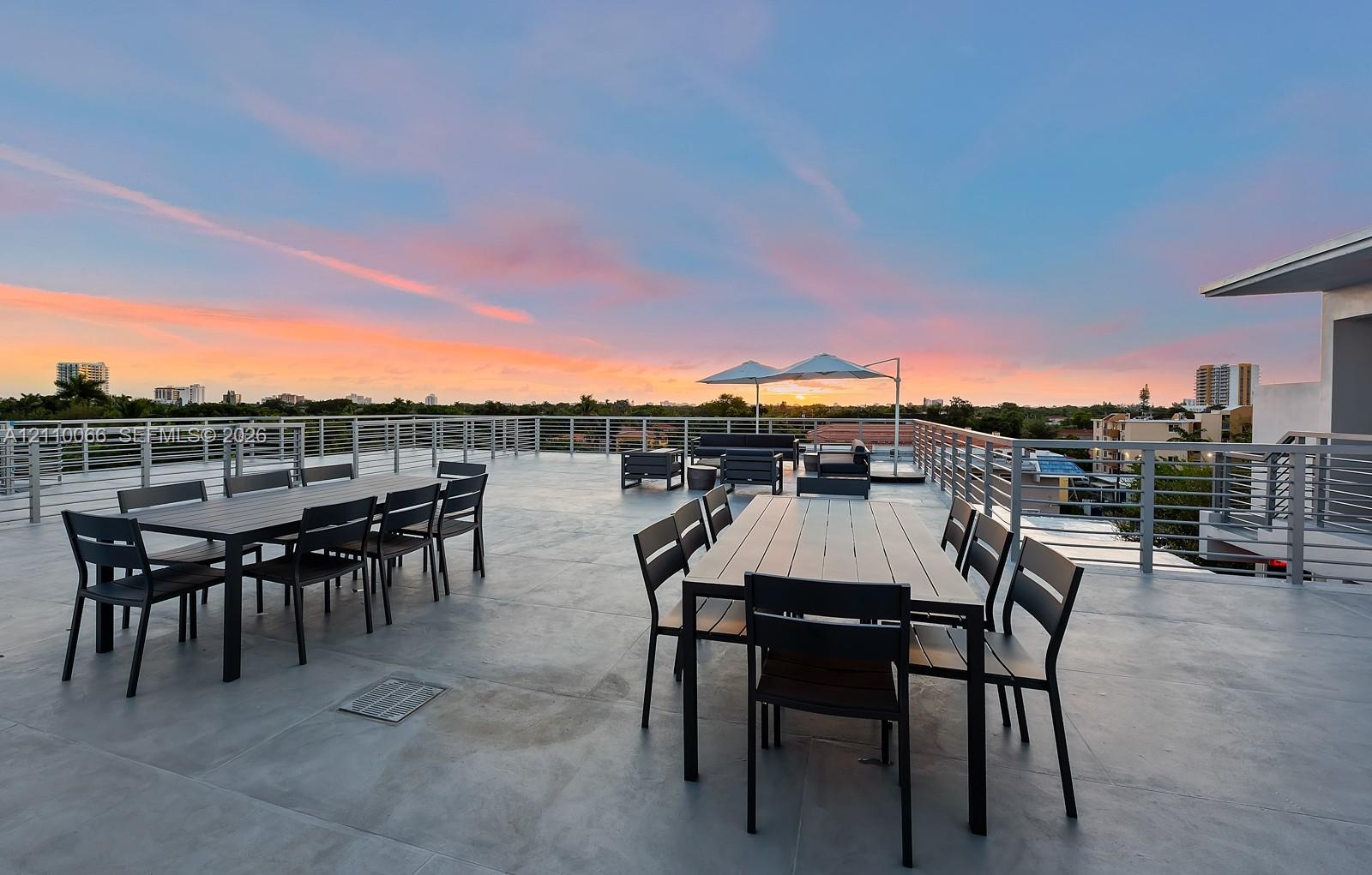 Expansive rooftop terrace featuring smooth concrete flooring and horizontal metal railings