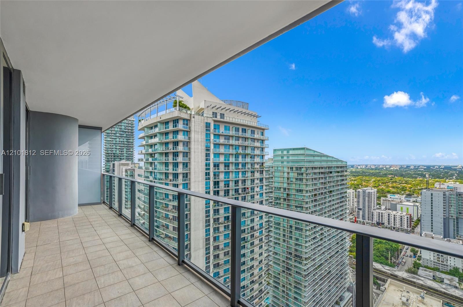 Private balcony featuring square tile flooring and a glass-paneled railing