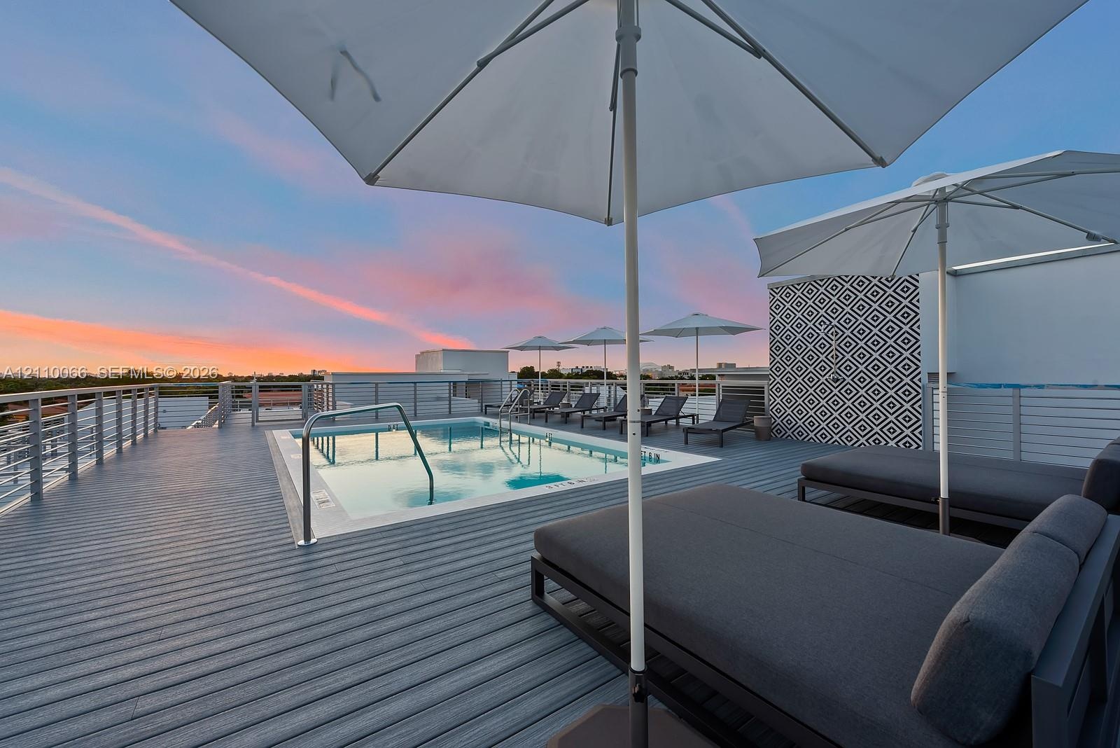 Rooftop deck featuring a swimming pool, horizontal cable railings, and patterned accent tiling