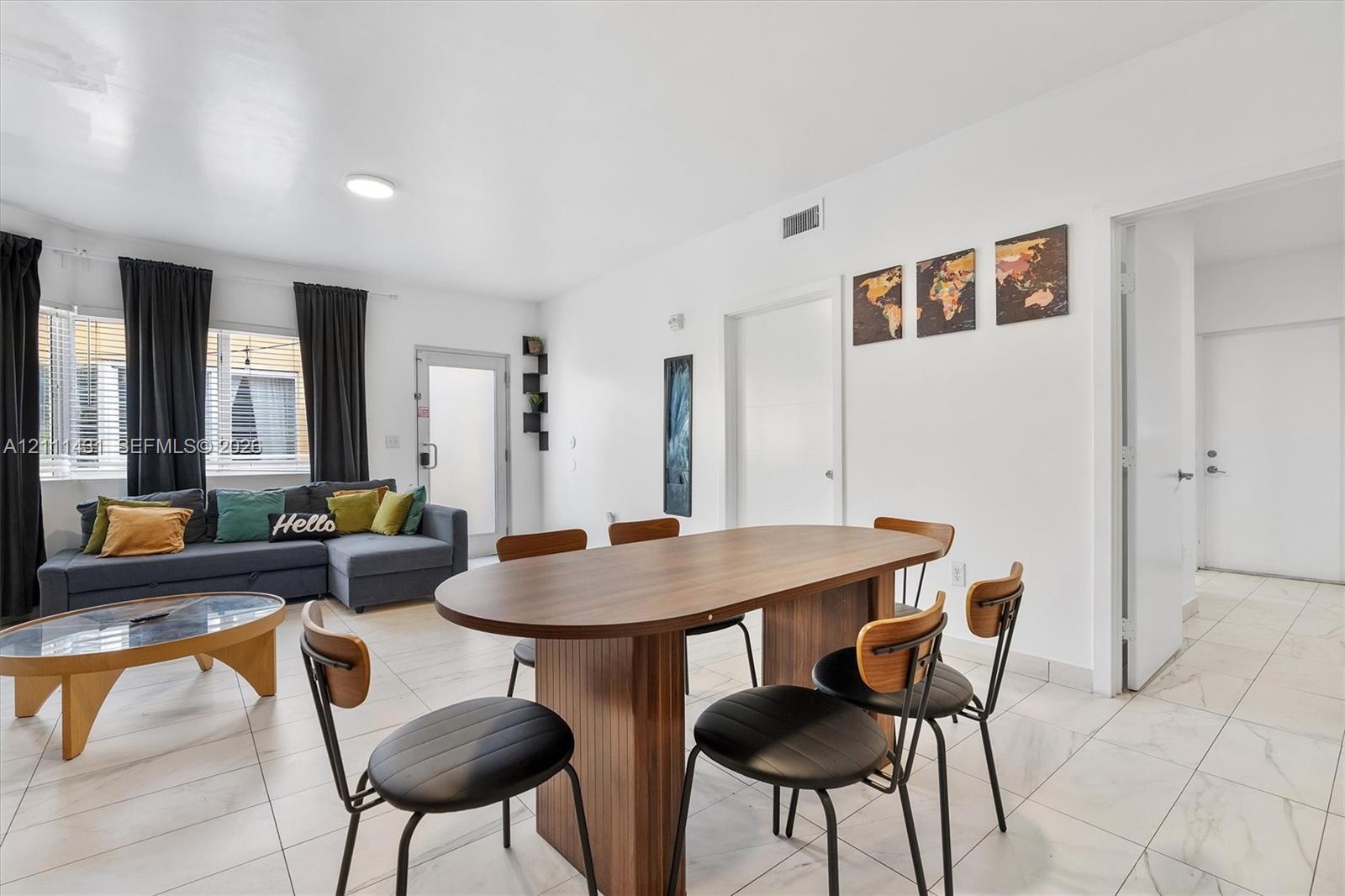 Open-concept interior featuring light-toned tile flooring, neutral wall finishes, and large windows