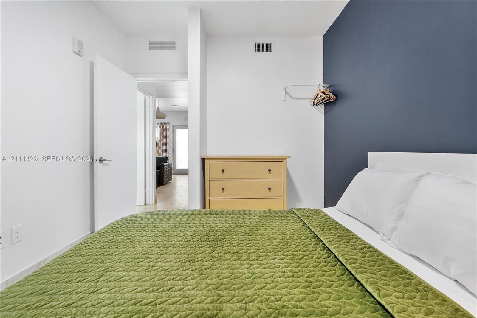 Bedroom featuring a charcoal-toned accent wall and white interior walls