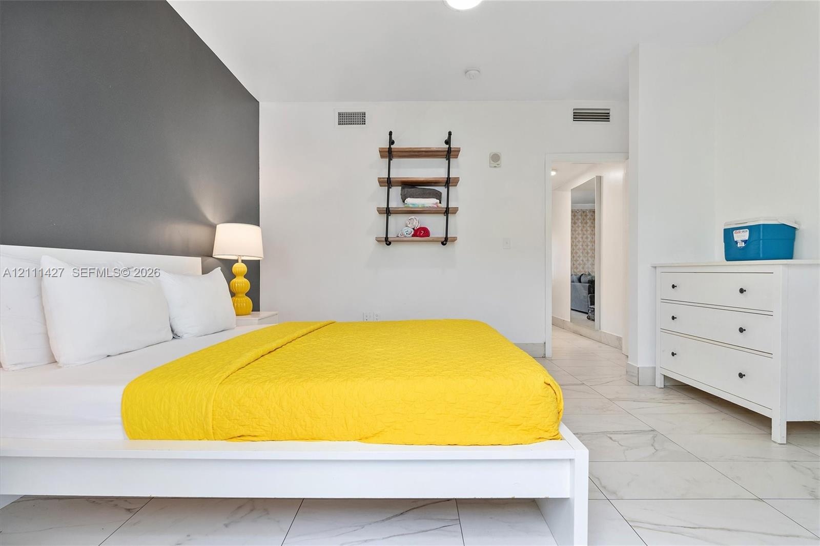 Room featuring tile flooring, a charcoal accent wall, and wall-mounted industrial shelving