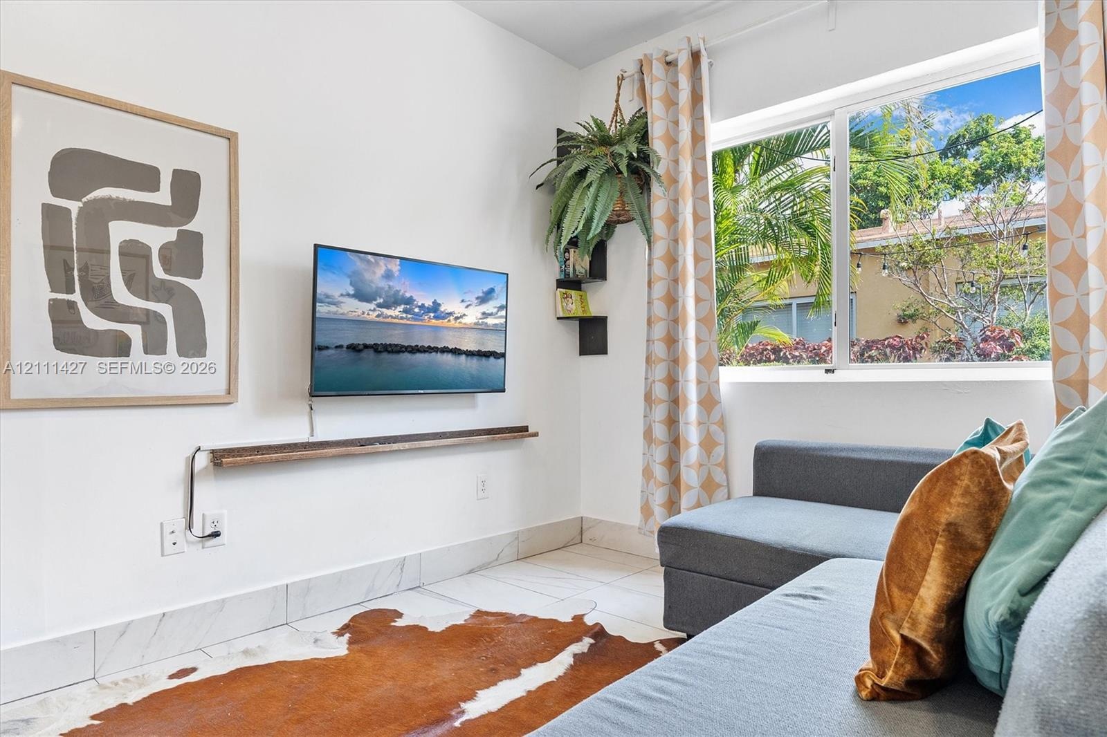 Large horizontal window, stone-finish flooring, and built-in floating wooden shelf