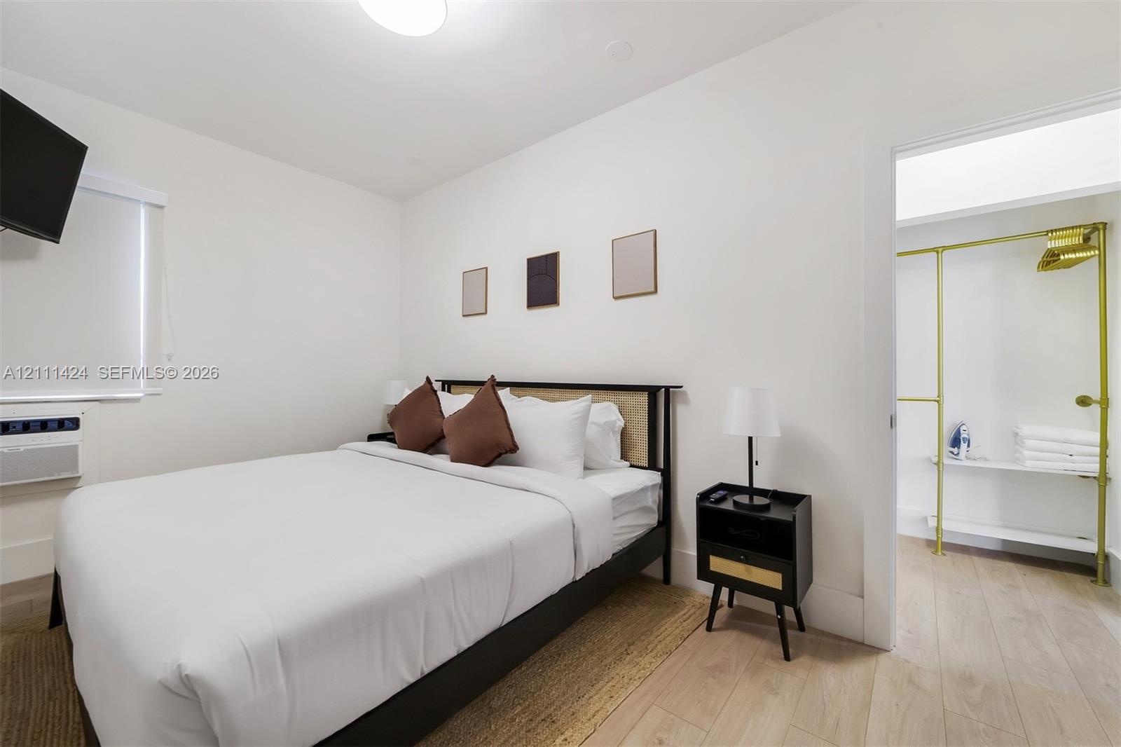 Wood-finish flooring, white walls, and built-in metal shelving