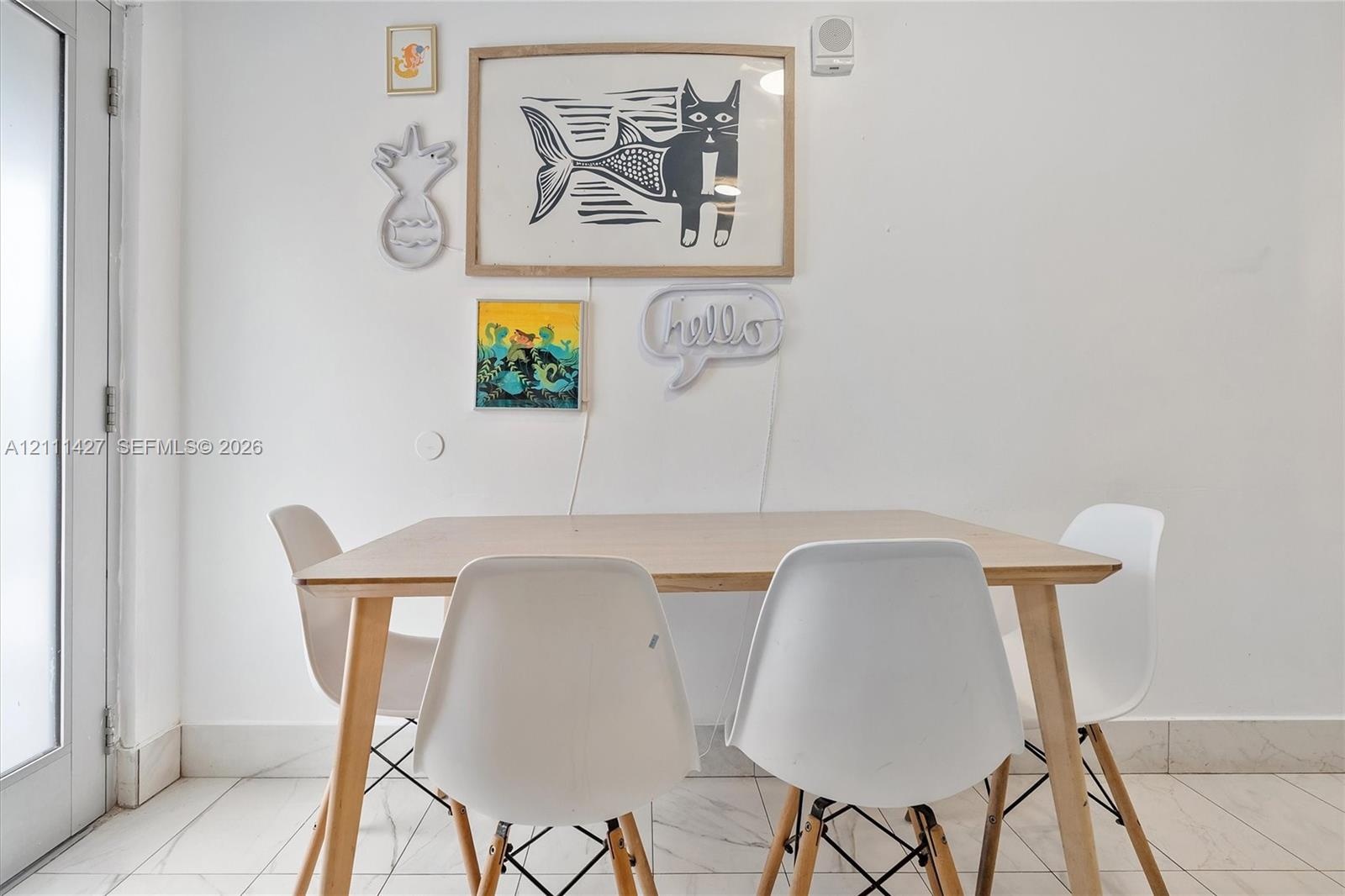 Light-toned stone-finish flooring and full-height glass door panel