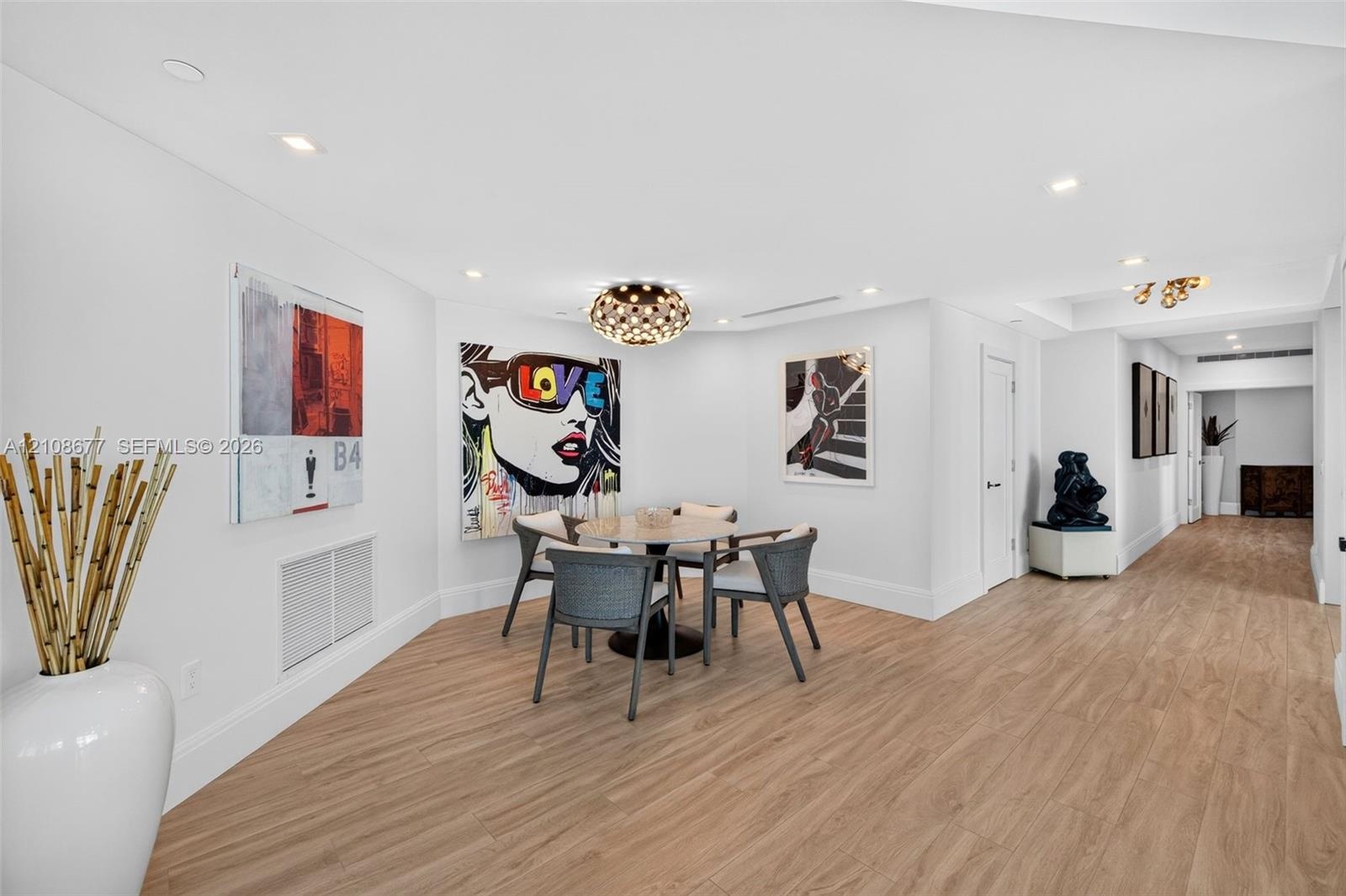 Open concept informal dining area or space for your future card table, featuring wood look plank porcelain flooring, recessed lighting, and a gorgeous