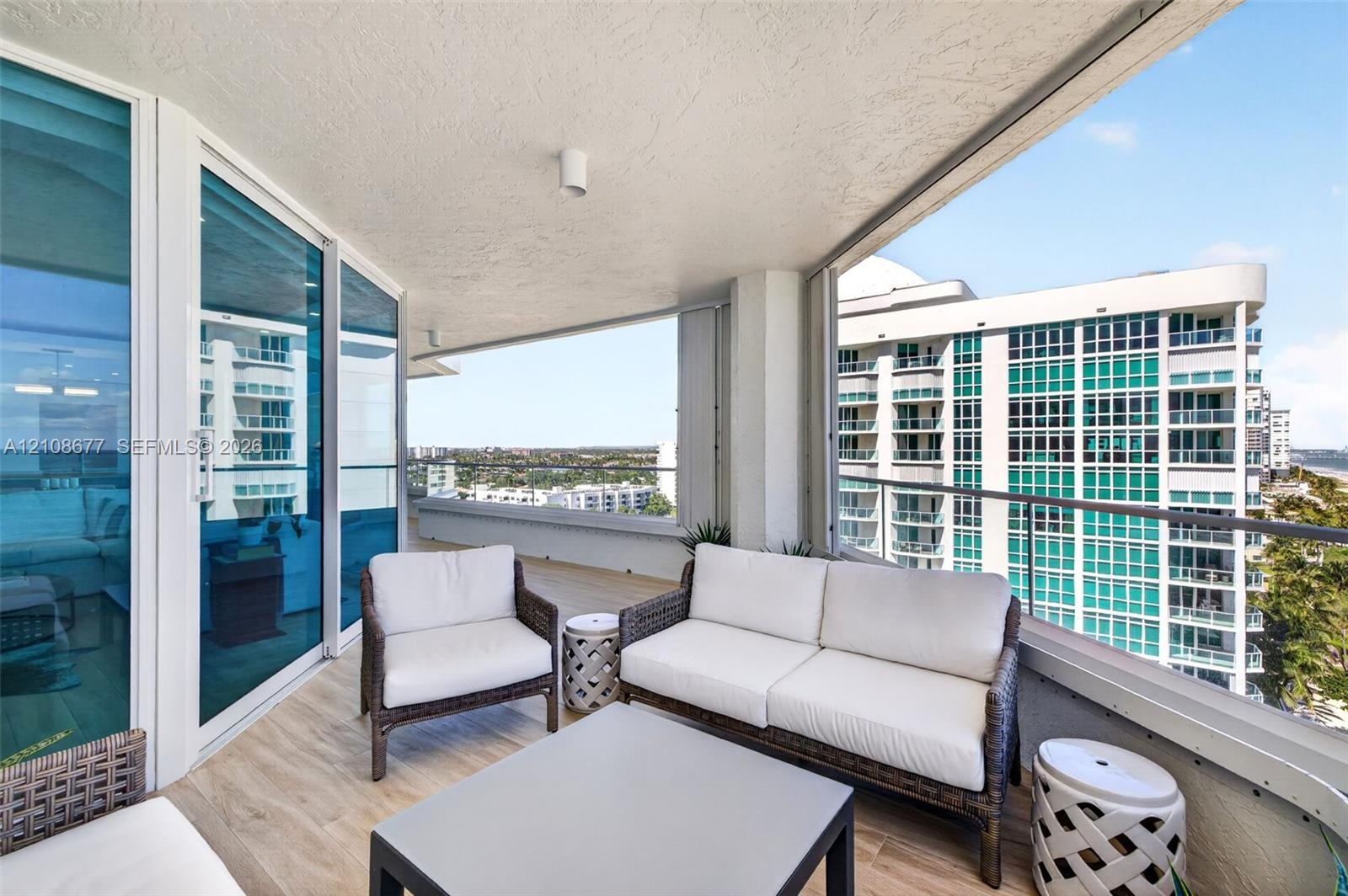 Covered balcony featuring wood look plank porcelain flooring, floor-to-ceiling glass paneling, and a metal railing. Additional protection for your fur