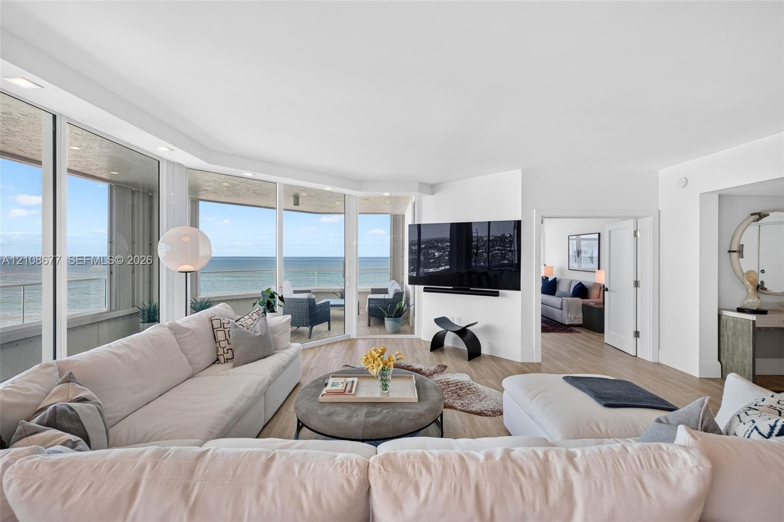 Floor-to-ceiling windows, wood look plank porcelain flooring, recessed lighting, and a private covered balcony. TV wall was expanded to accommodate a 