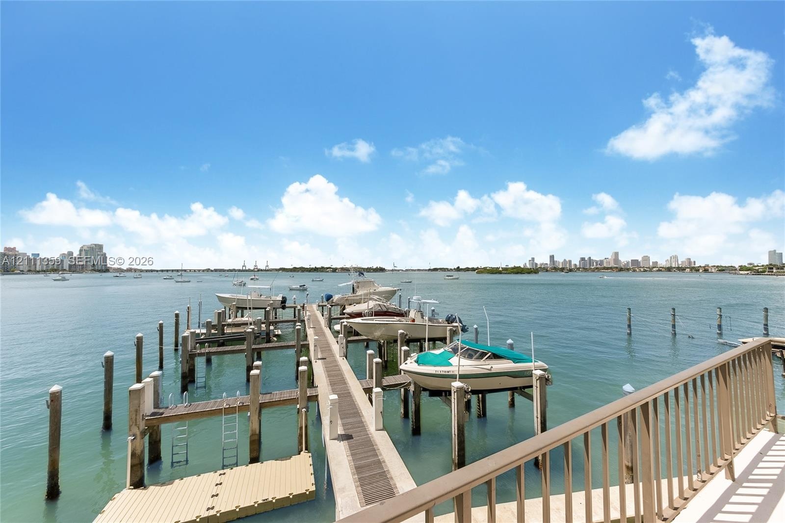 Waterfront dock featuring multiple boat slips, composite decking, and a metal railing system