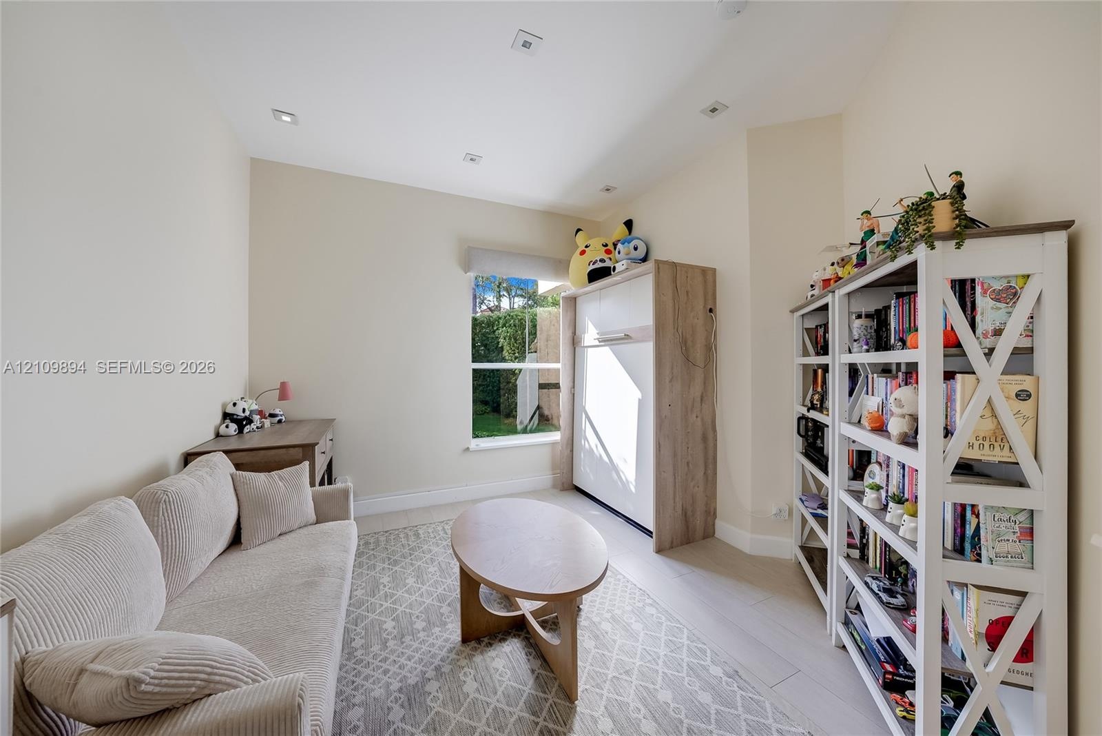 Interior room featuring neutral wall tones, wood-finish flooring, recessed ceiling lighting, and a single-pane window