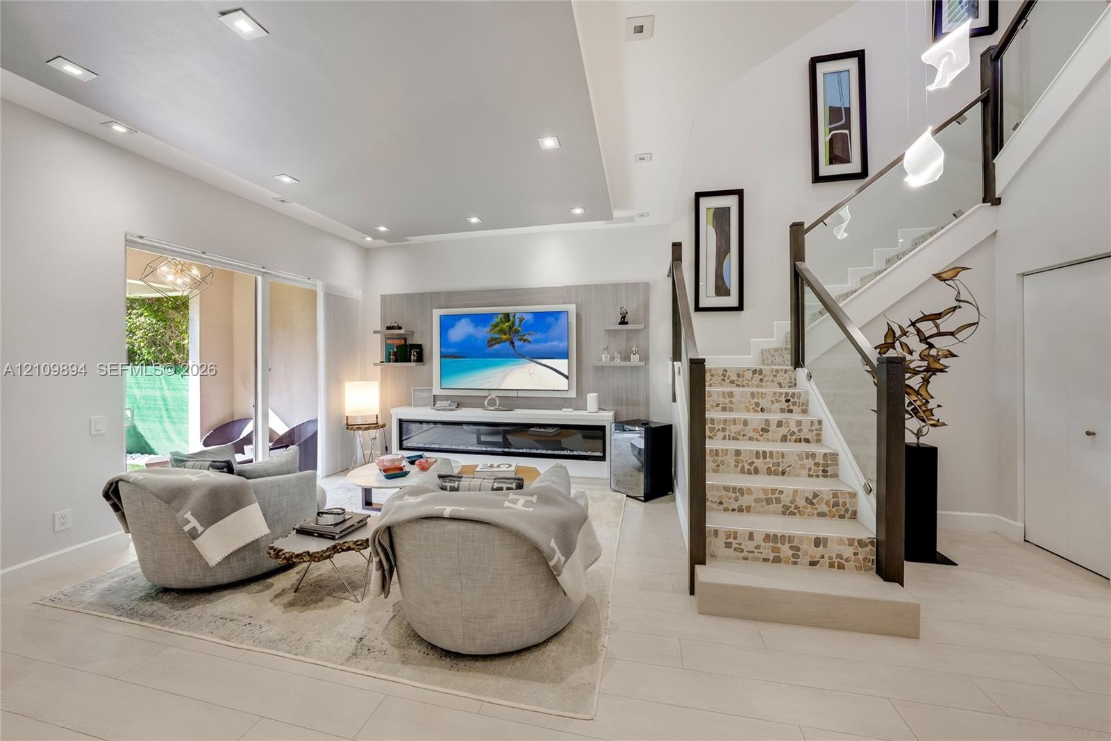 Living area featuring recessed lighting, a built-in linear fireplace with surround shelving, tile-finish flooring, and a staircase with glass railings