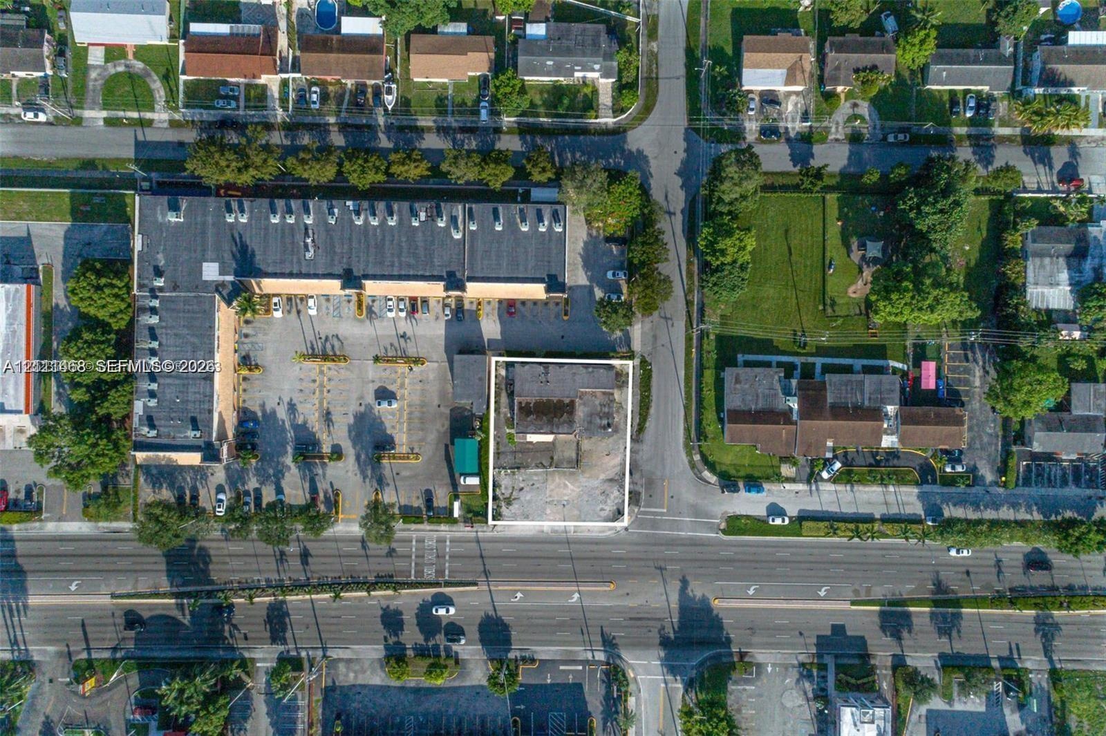 Corner lot featuring paved surface area, rectangular footprint, and direct exposure to primary roadway