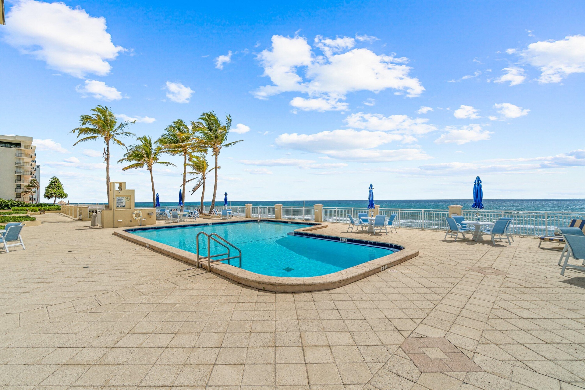 Expansive outdoor patio with a swimming pool, oceanfront setting