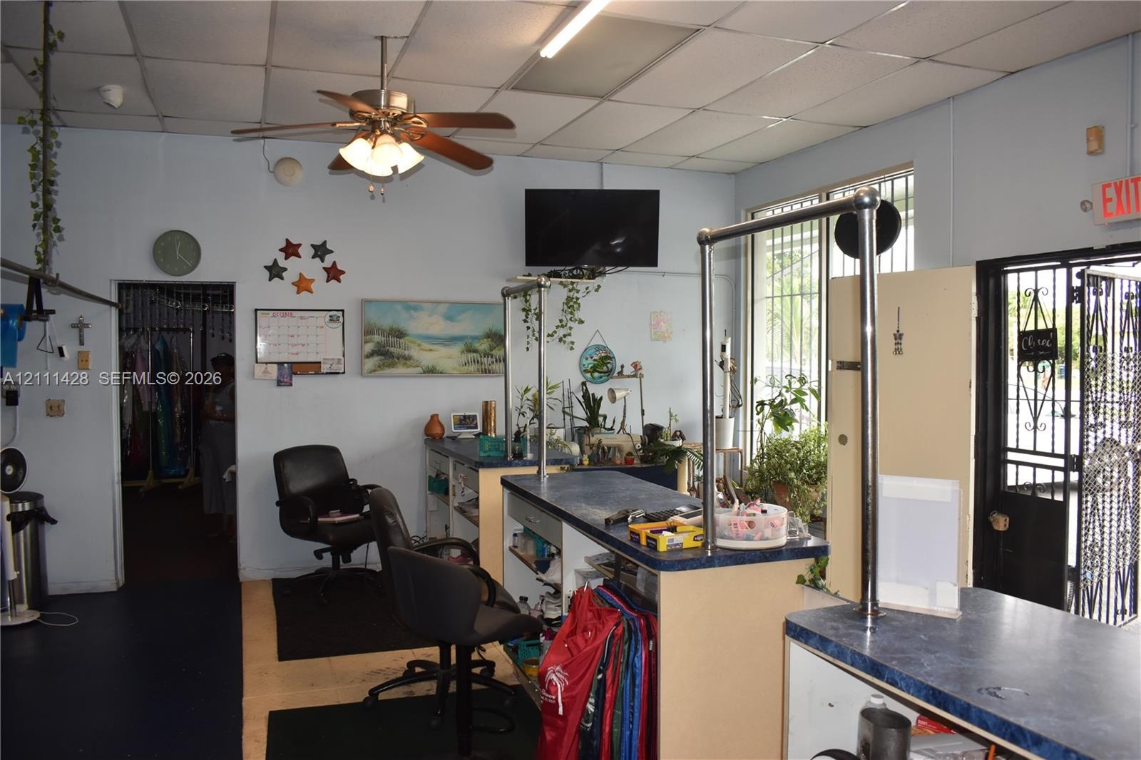Drop ceiling with integrated lighting, ceiling fan, and built-in service counter