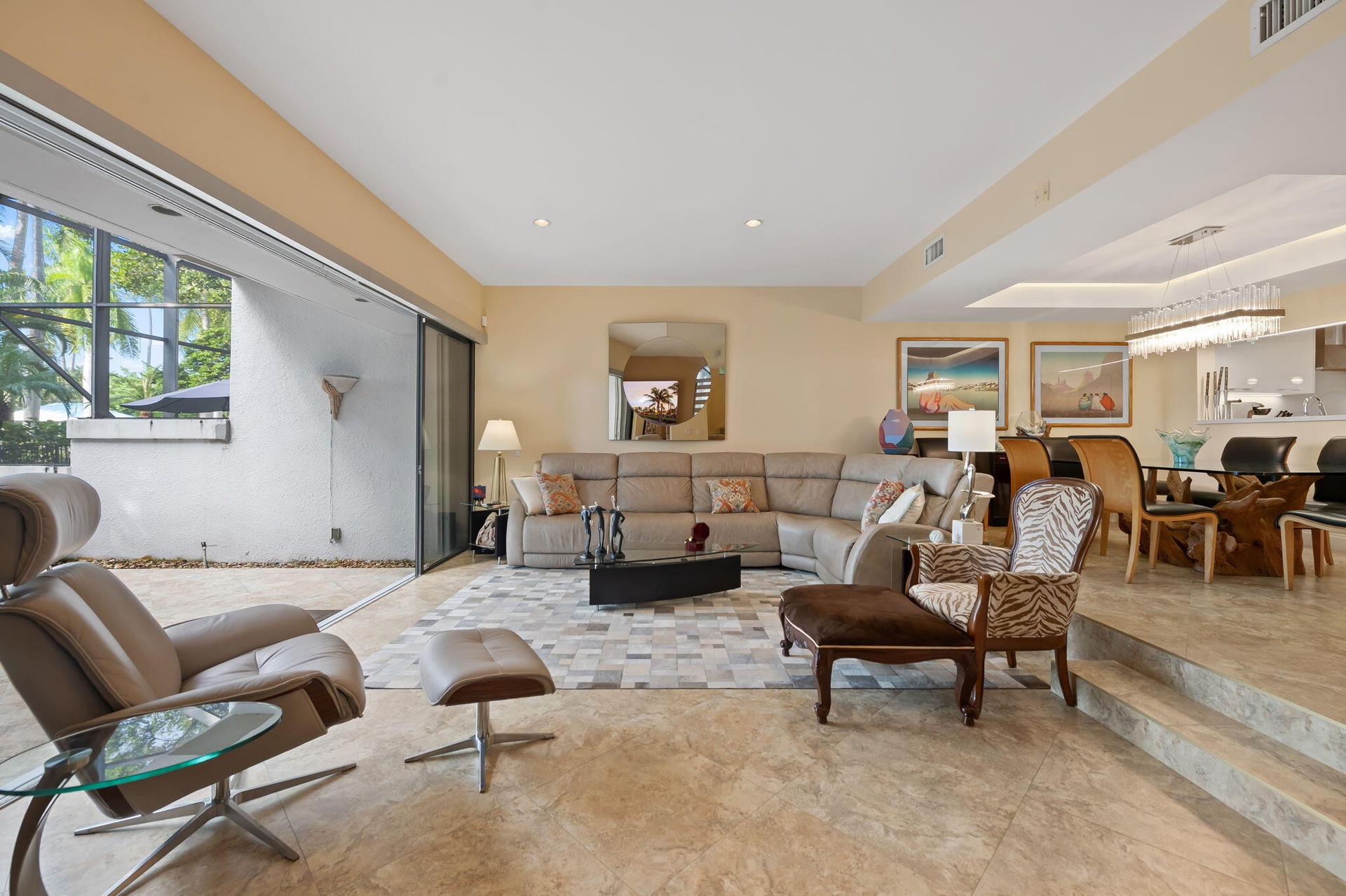 Large-format retractable sliding glass doors, tile flooring, recessed lighting, and a multi-tiered interior layout