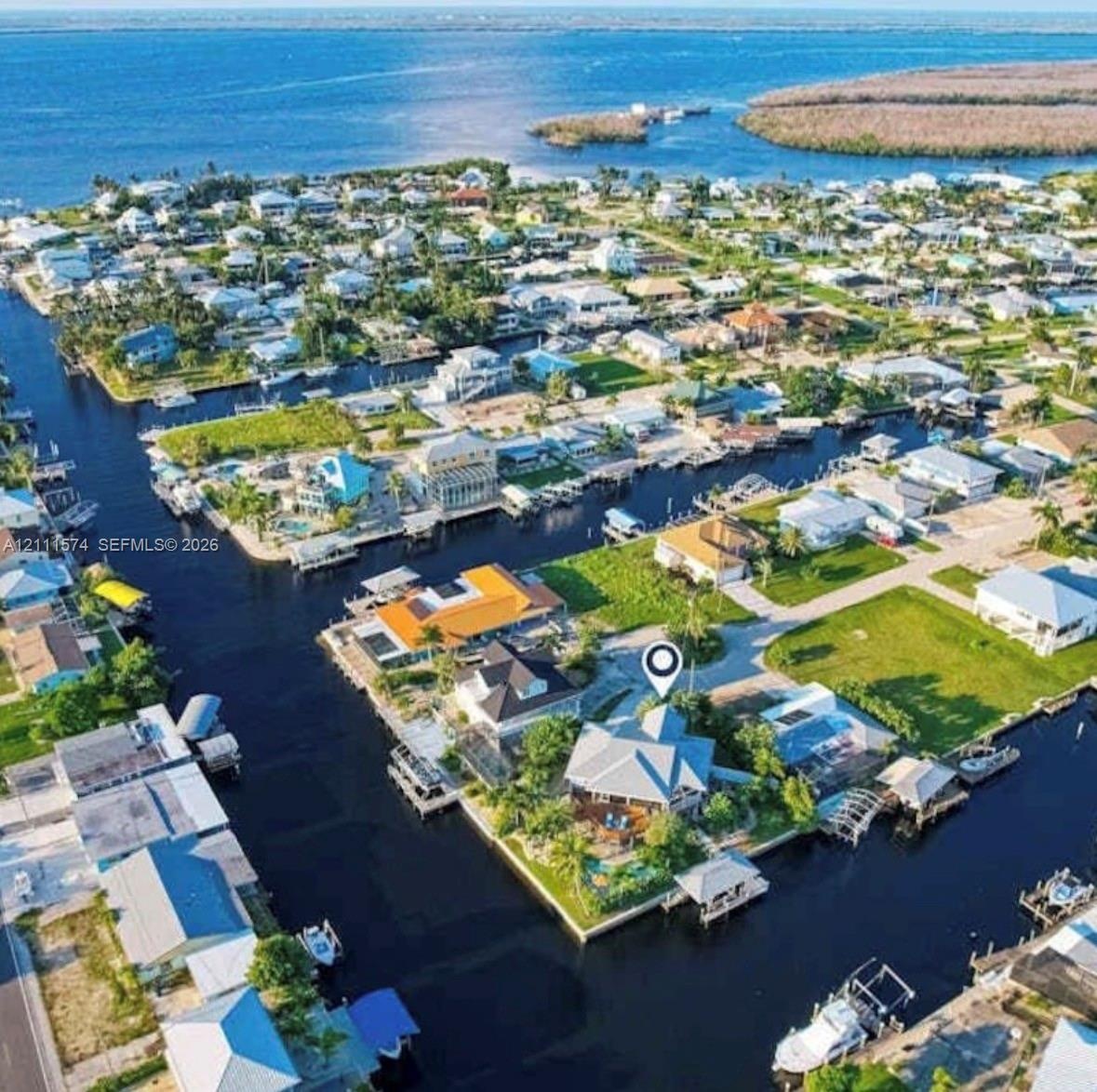 Waterfront property featuring deep-water canal access, private boat dock, multi-sided perimeter bulkhead, and mature landscaping