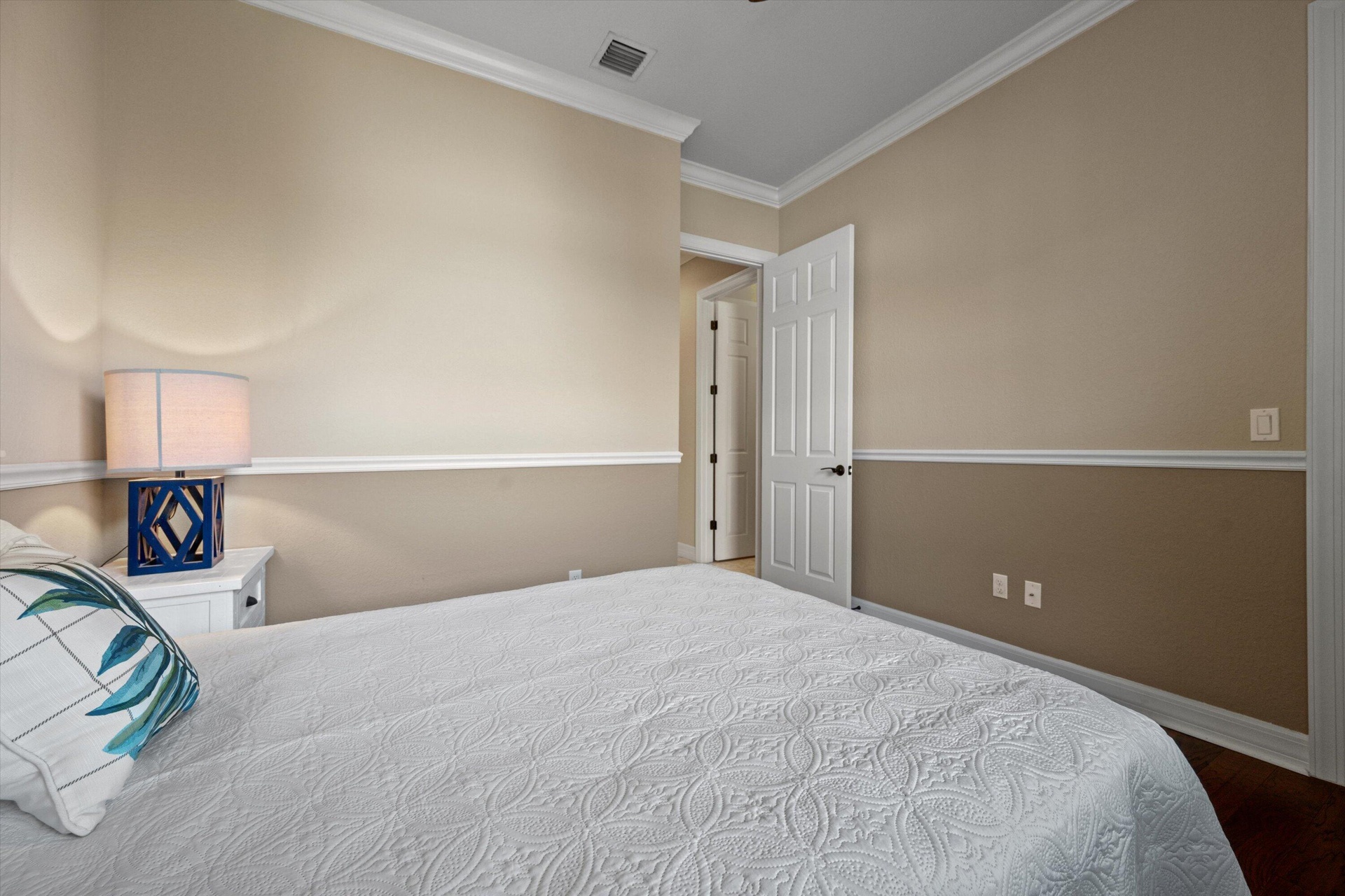 Room featuring crown molding, chair rail detailing, two-tone wall finish, and a six-panel door