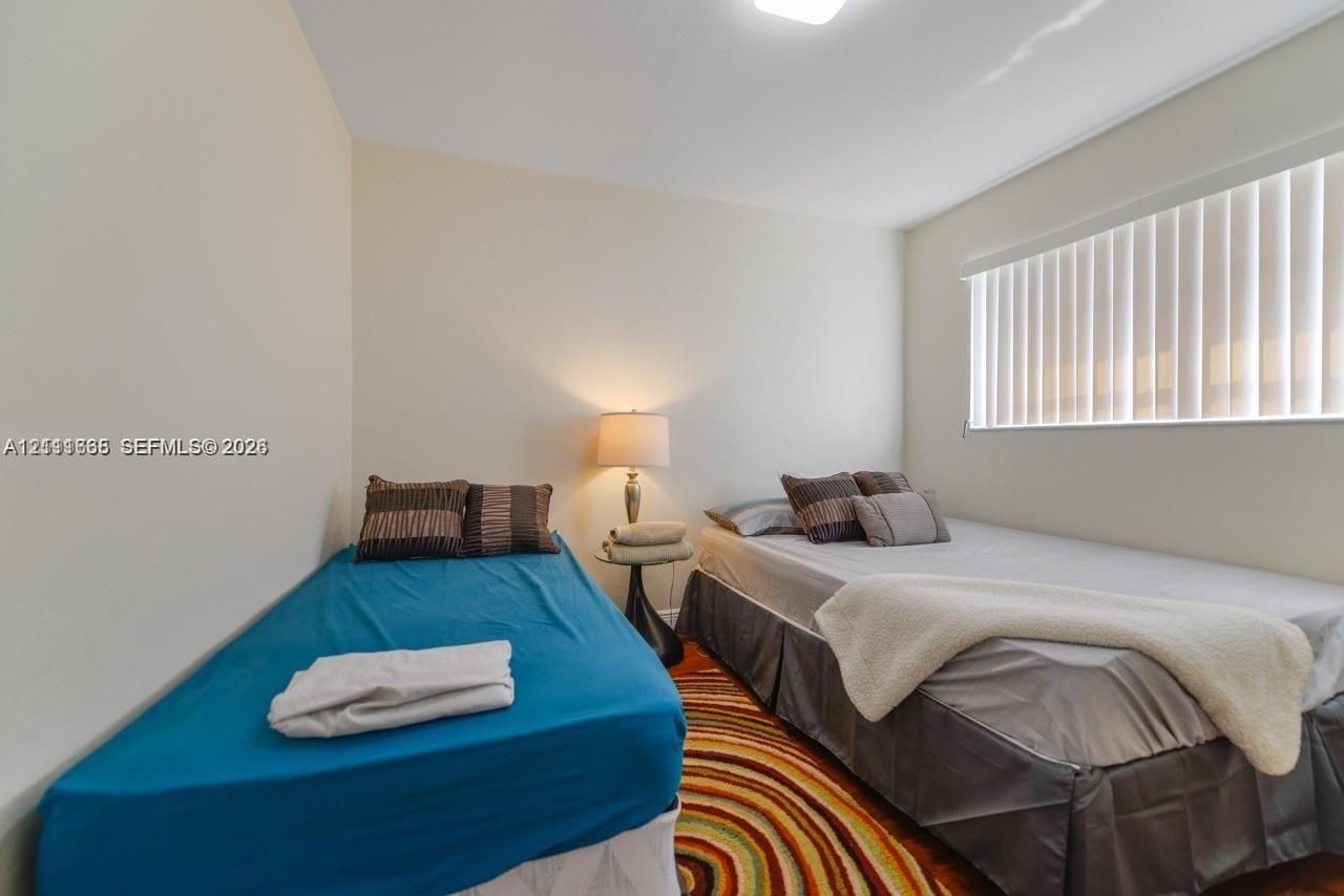 Room featuring wood-finish flooring and a horizontal window with vertical blinds