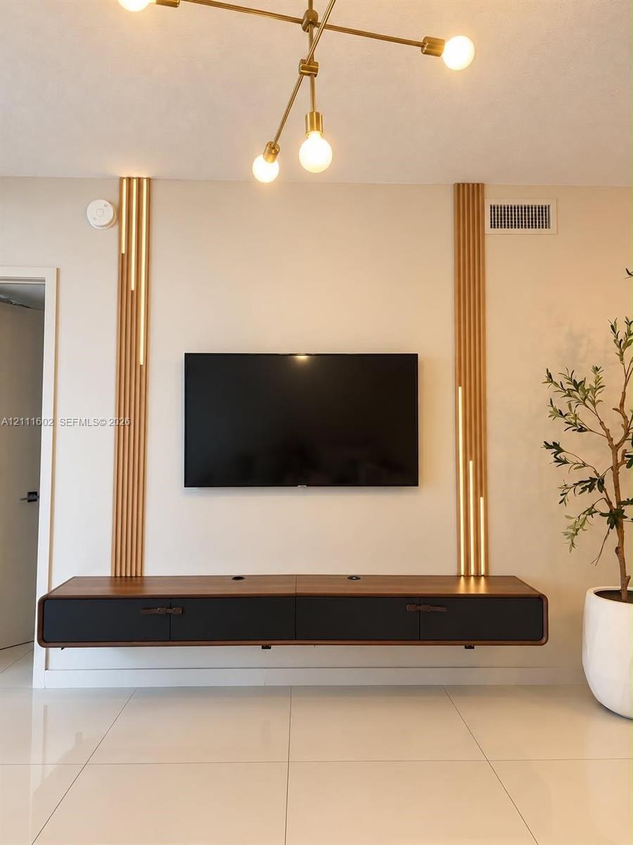 Wall-mounted floating media console featuring a two-tone wood and matte black finish, accented by vertical wood slat wall detailing with integrated li