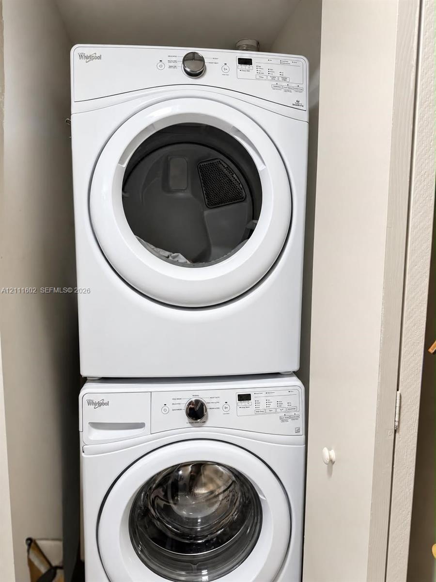 Stackable Whirlpool washer and dryer unit with front-loading glass doors and digital control panels