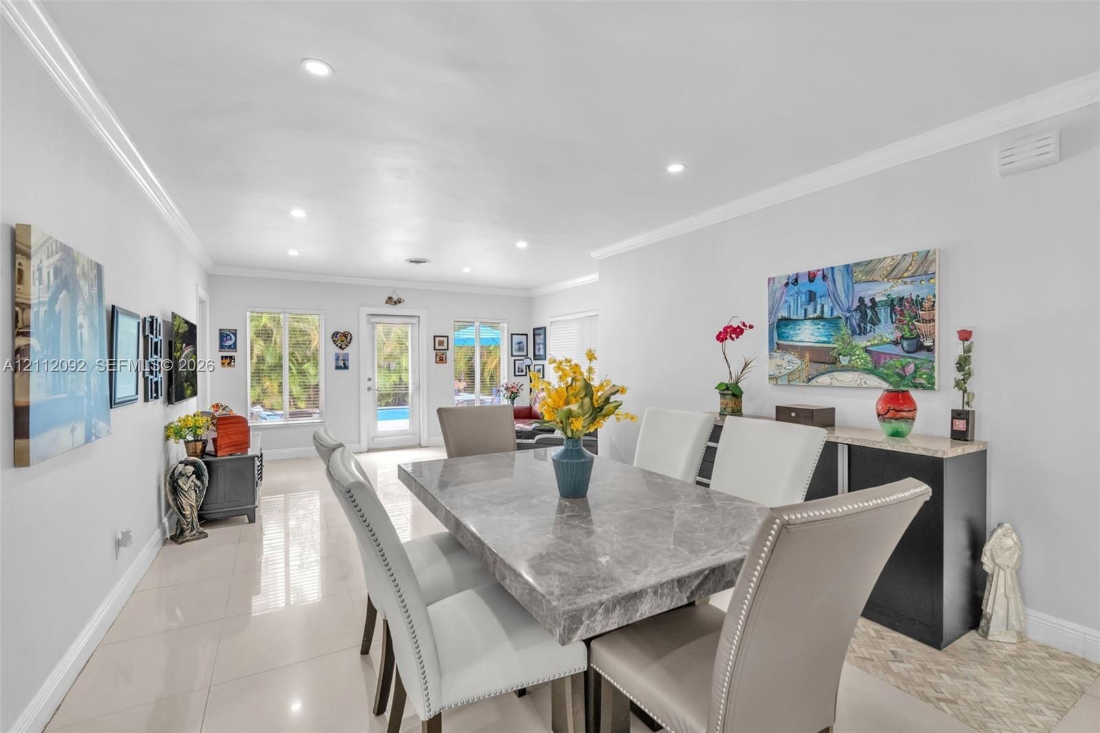 Open-concept interior featuring large-format tile flooring, recessed lighting, and crown molding