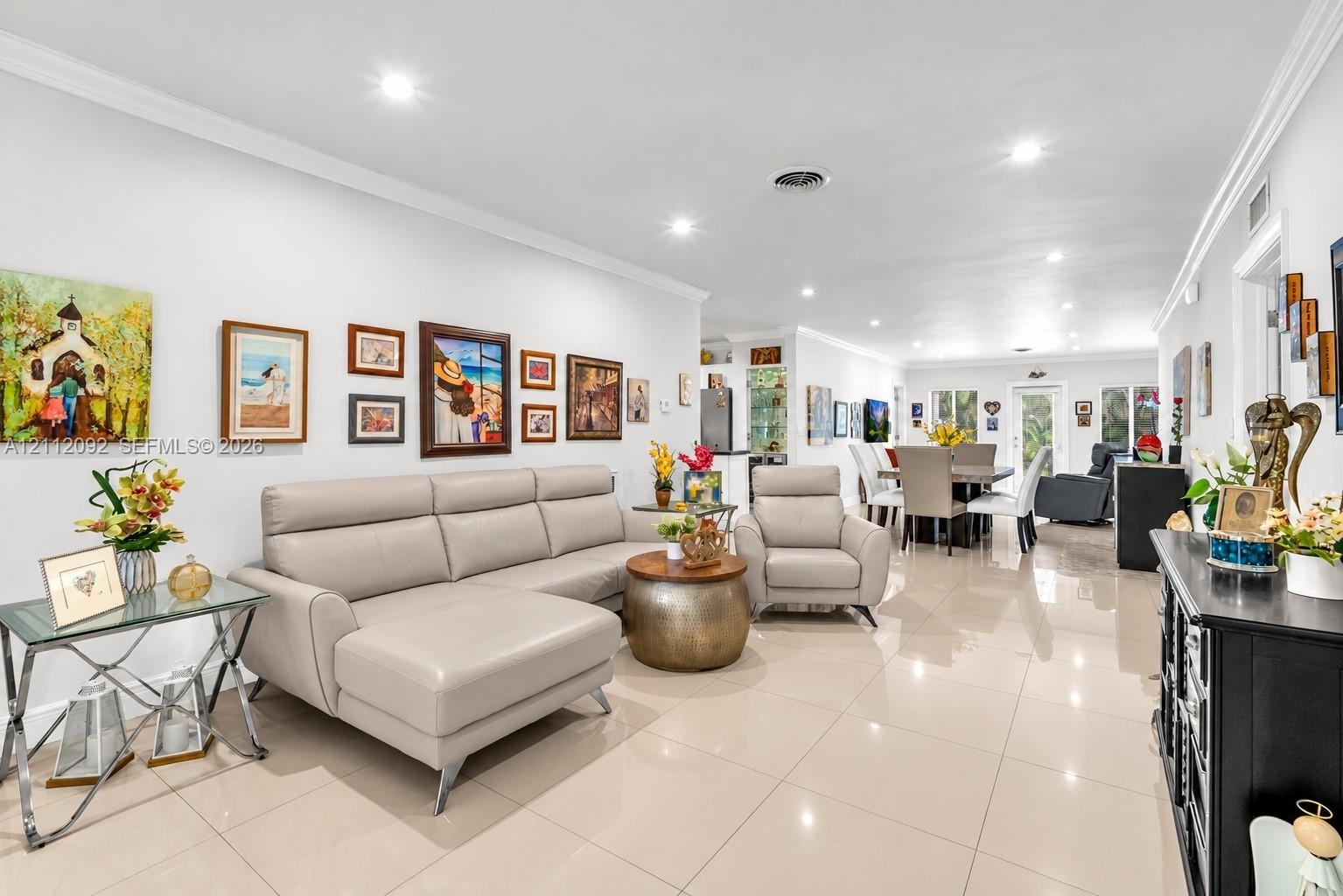 Neutral-toned polished tile flooring, recessed lighting, crown molding, and a front entry door featuring frosted glass paneling
