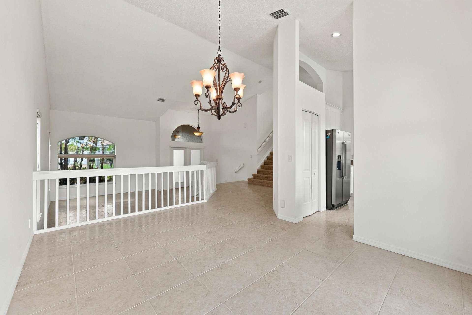 The formal dining room features impressive ceiling heights, decorative lighting, and an open design that adds to the home's spacious character