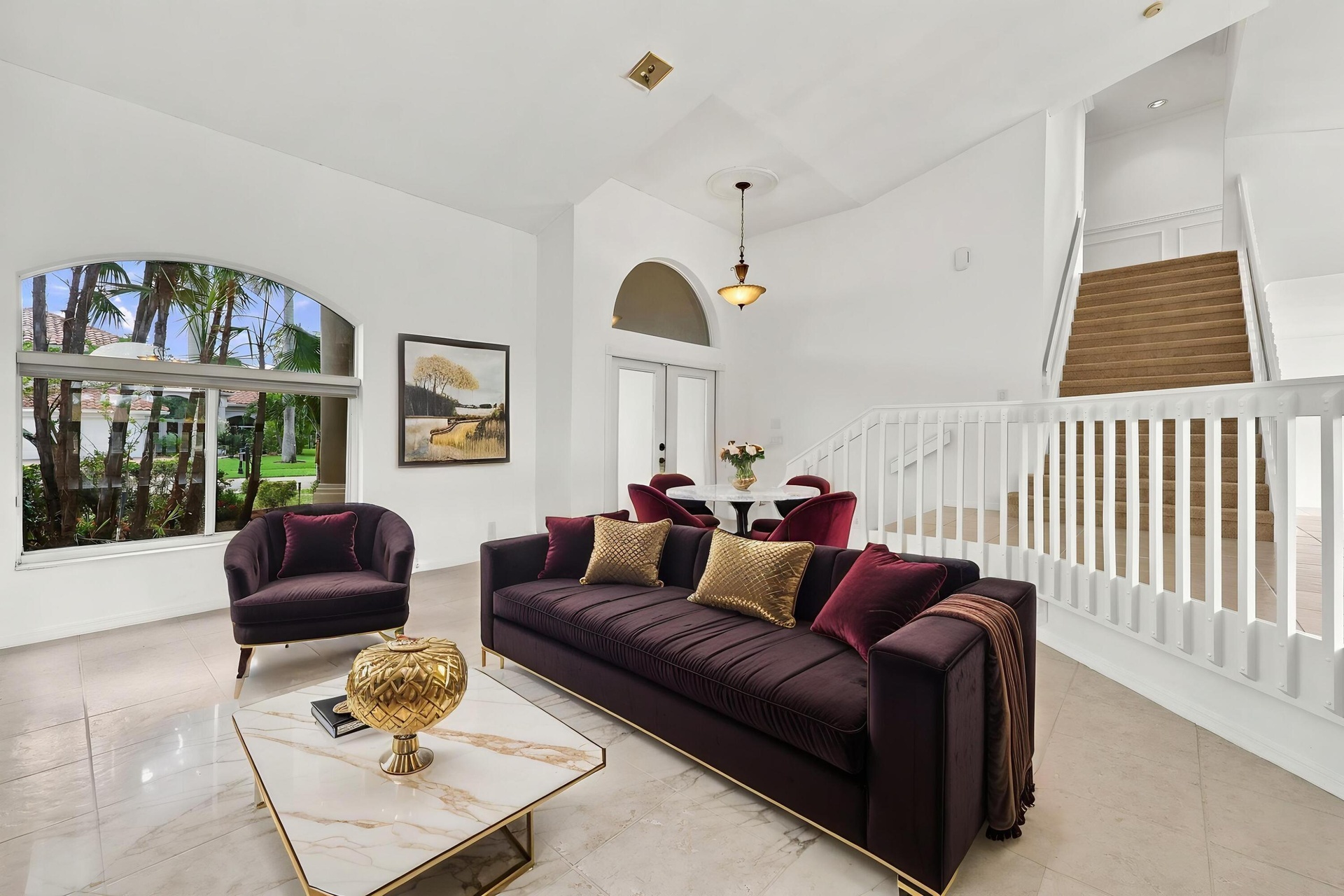 Impressive formal living room with dramatic vaulted ceilings, oversized arched windows, and an open, airy design that creates a wonderful first impres