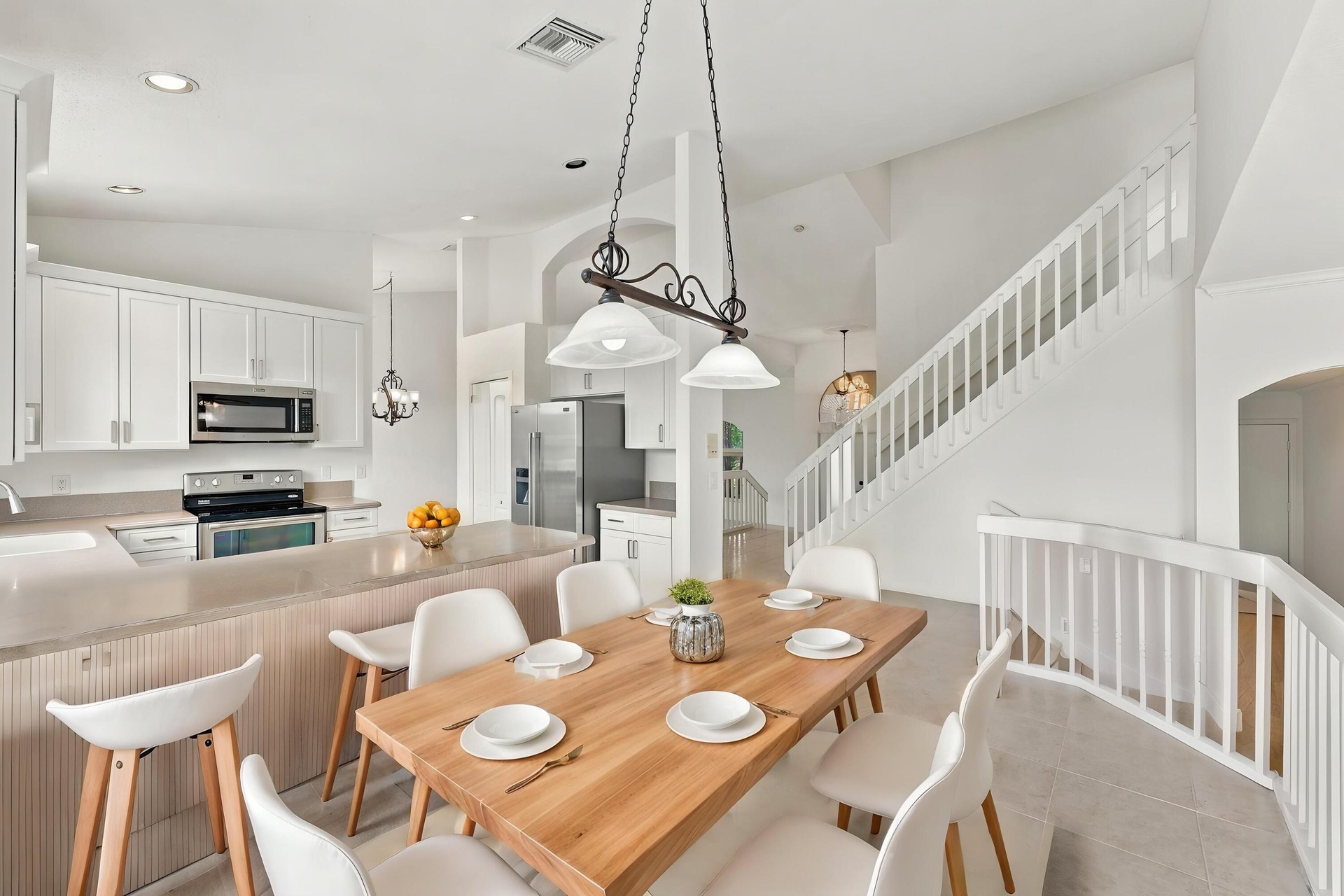 An inviting kitchen and breakfast area featuring white cabinetry, generous counter space, and an open design that connects seamlessly to the surroundi