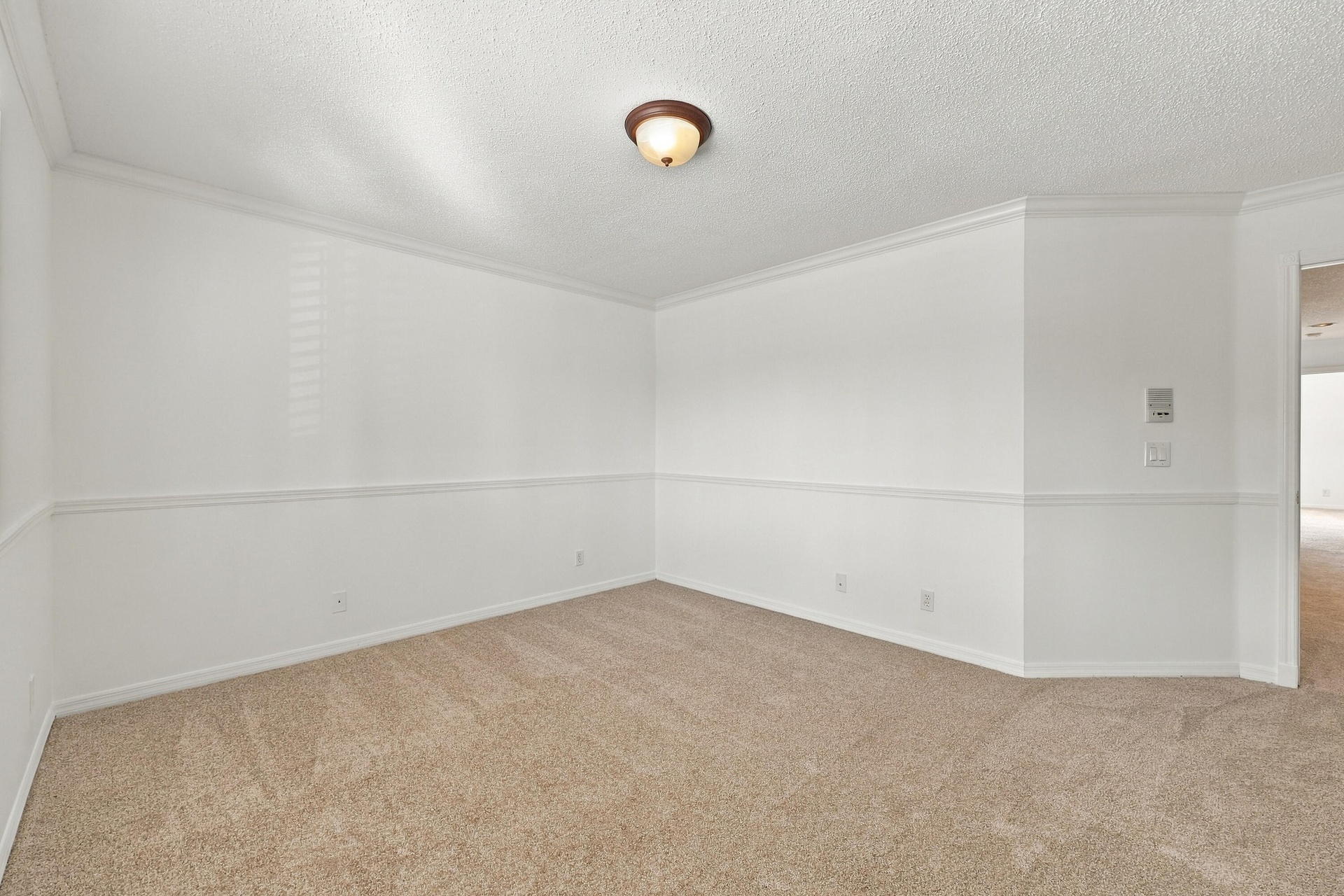 With its generous proportions, neutral carpeting, and decorative wall details, this bedroom offers flexibility for guests, family, or a home office.