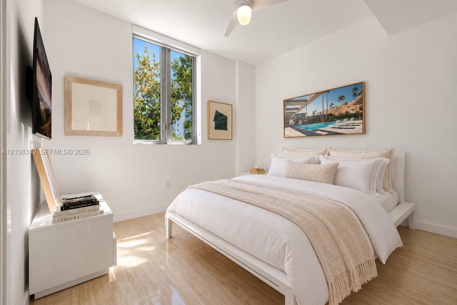 Bright room featuring wood-finish flooring, a vertical window, and a ceiling fan with integrated lighting