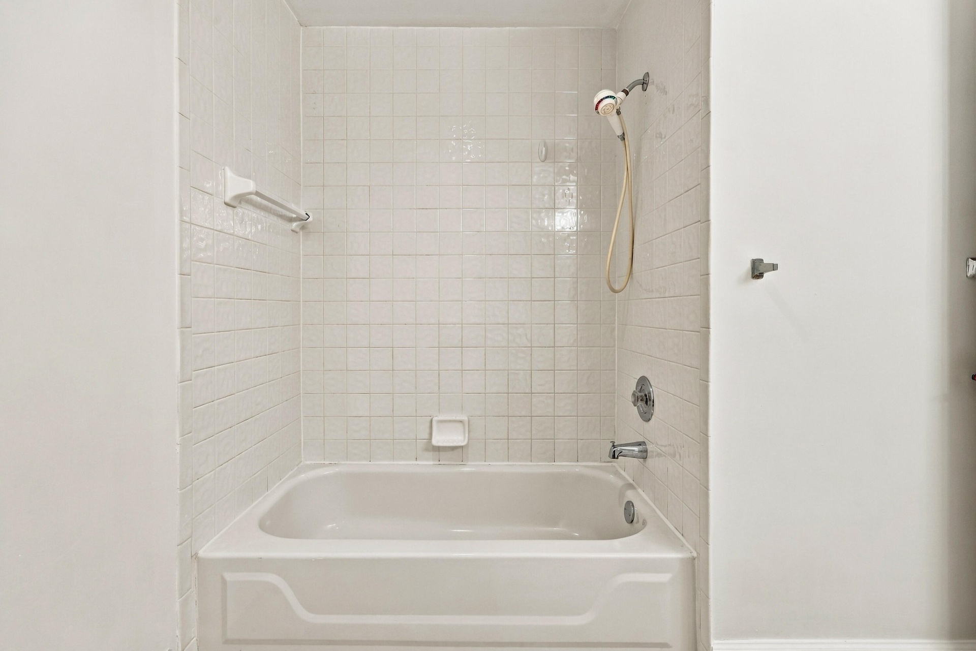 A convenient tub and shower combination with neutral tile surrounds provides comfort and functionality in this second-floor bathroom, ideally situated