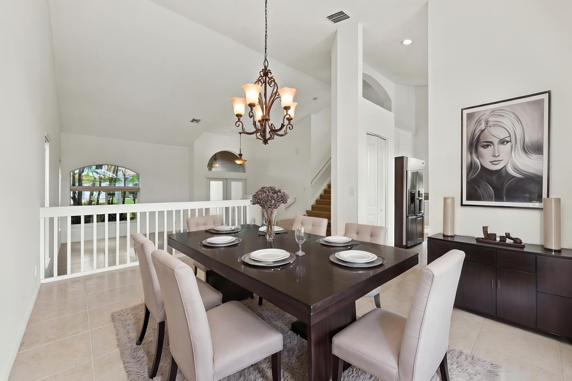 The formal dining room features impressive ceiling heights, decorative lighting, and an open design that adds to the home's spacious character