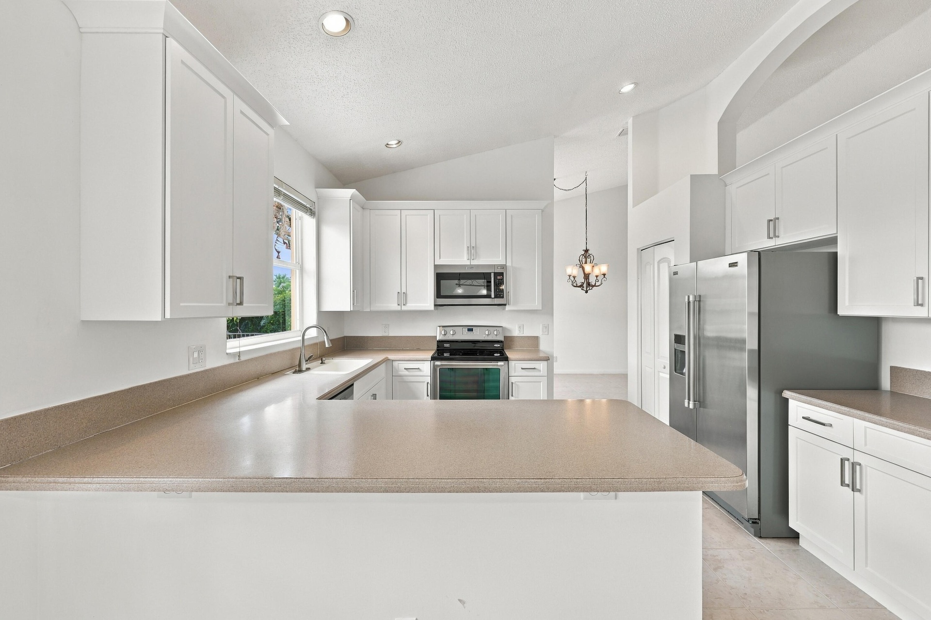 Generous countertop space, abundant cabinetry, and a practical U-shaped layout make this kitchen ideal for meal preparation, entertaining, and everyda