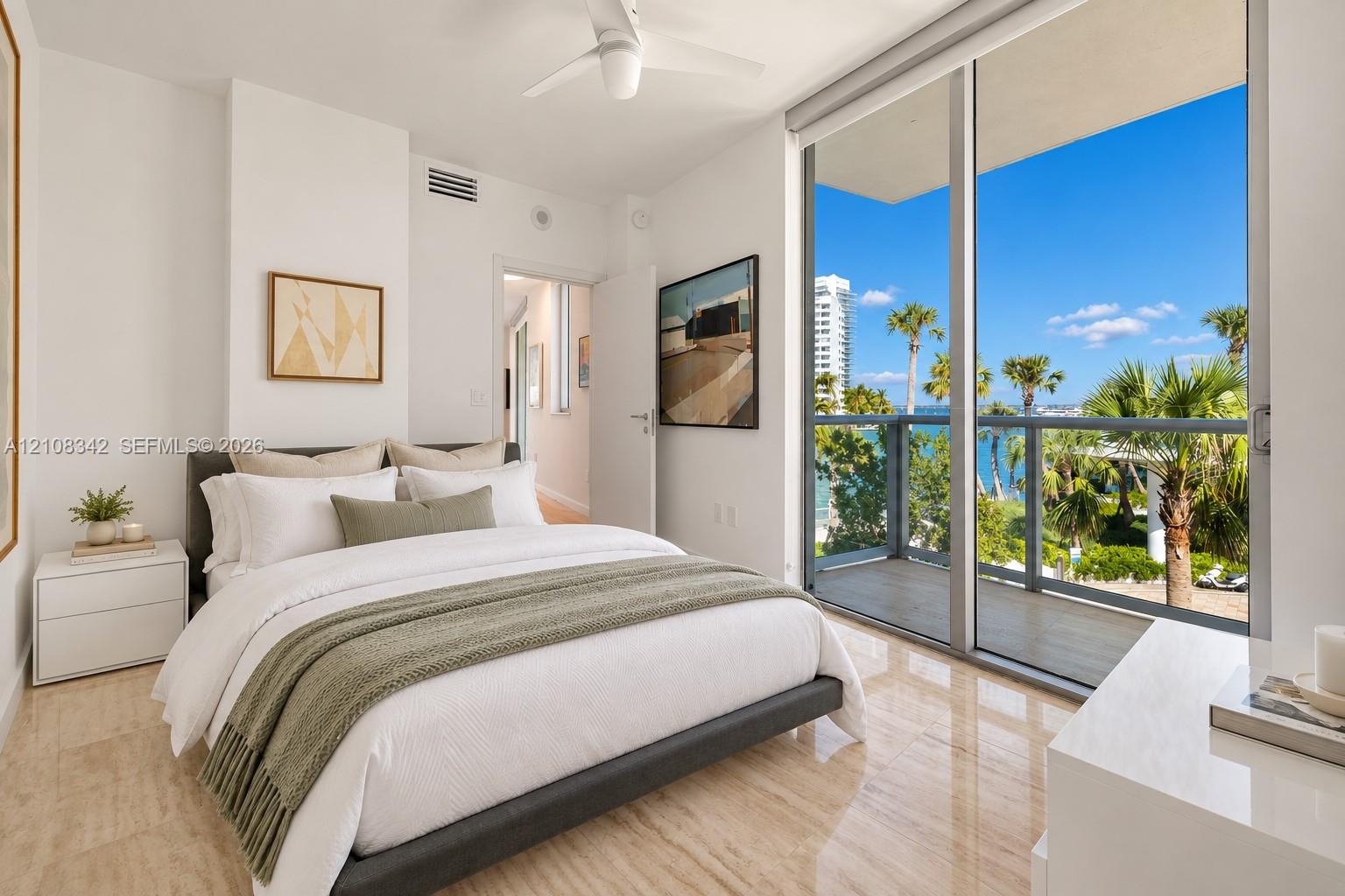 Floor-to-ceiling sliding glass doors, private balcony, polished stone flooring, recessed ceiling fan, and crisp white wall finishes