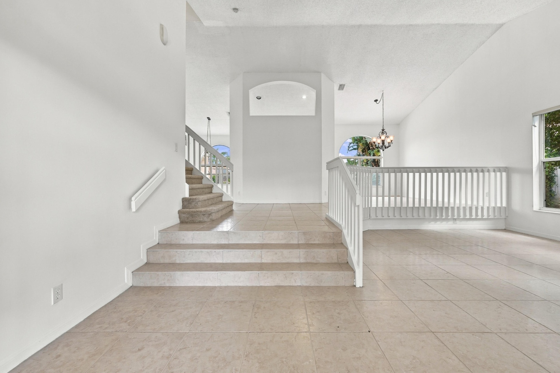 An elegant staircase with white railings complements the home's spacious, multi-level design, creating an inviting transition between living spaces.