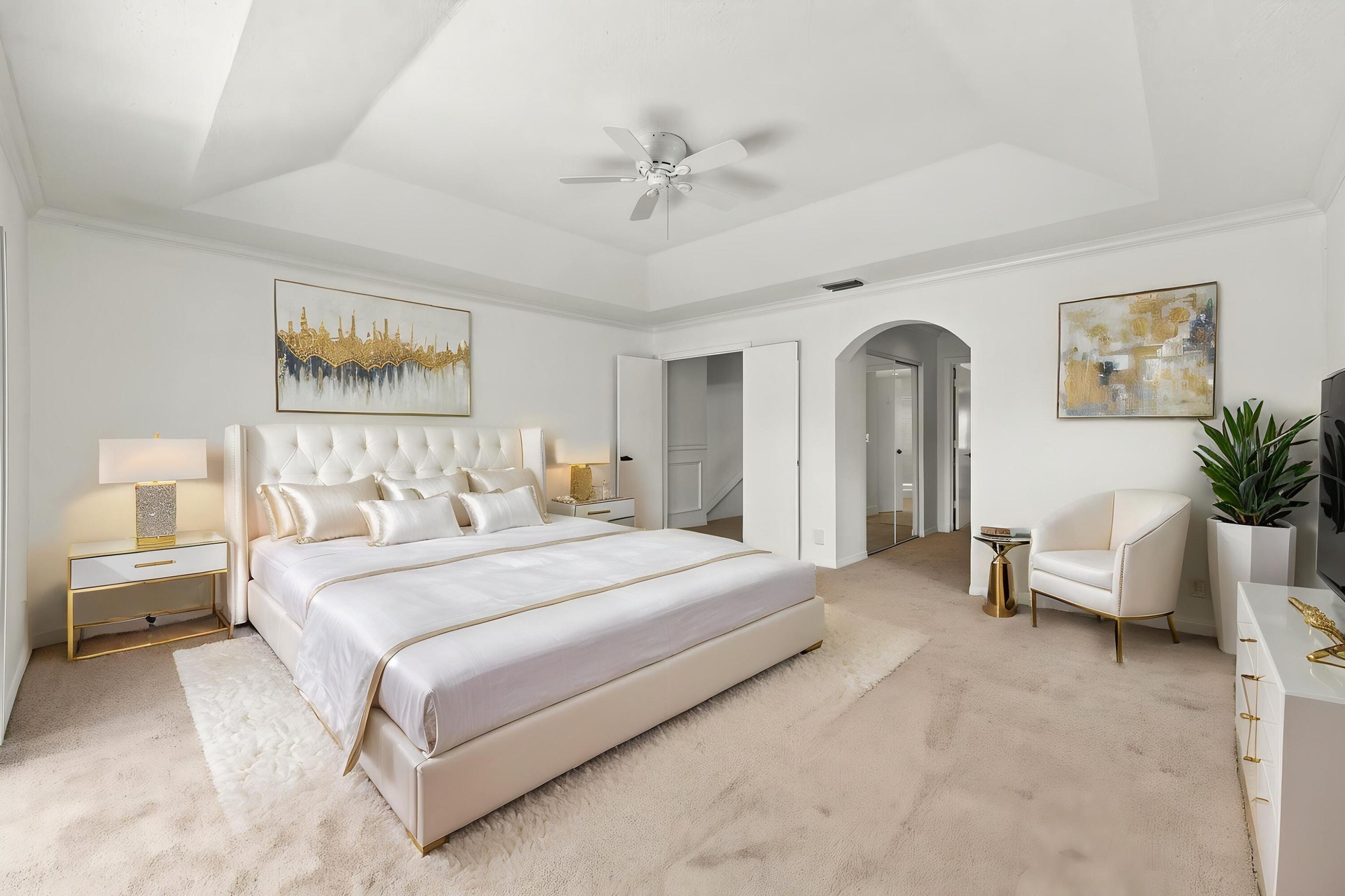 This generously sized primary suite offers an elegant tray ceiling, plush carpeting, and an expansive layout with plenty of room to create your own pe