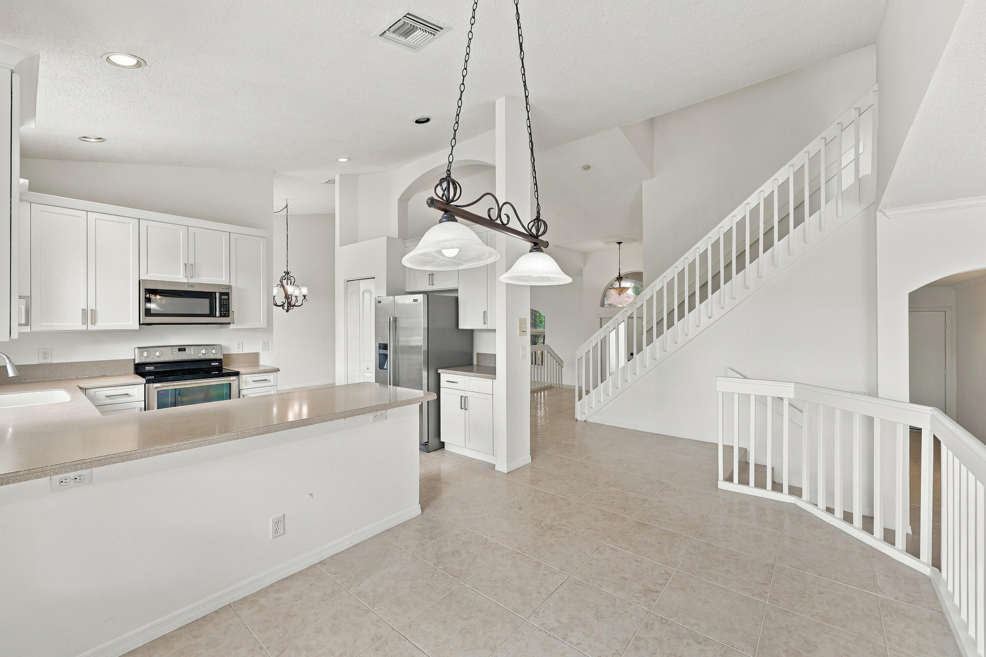 An inviting kitchen and breakfast area featuring white cabinetry, generous counter space, and an open design that connects seamlessly to the surroundi