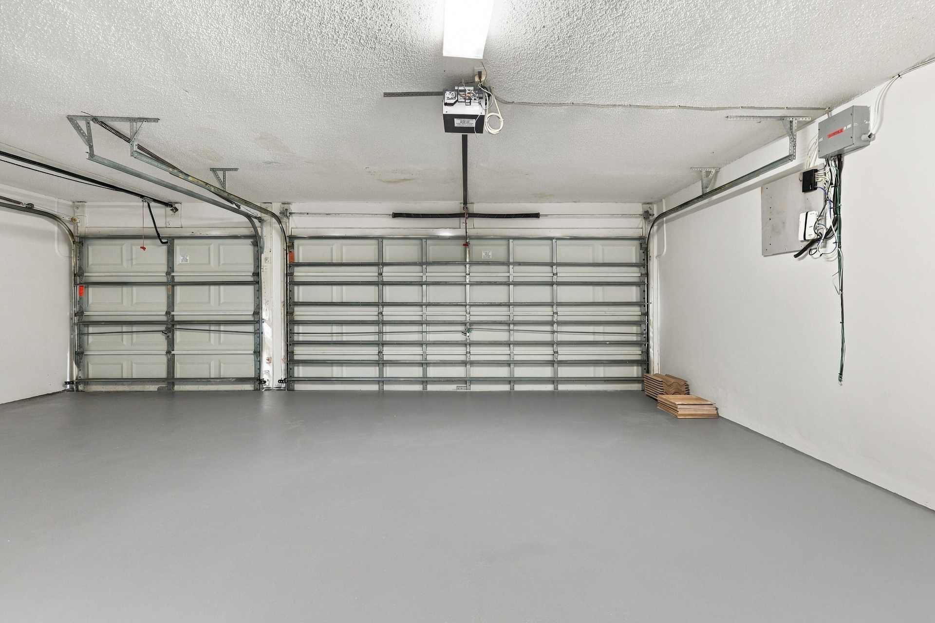 An impressive three-car garage featuring a finished floor, multiple overhead doors, and exceptional room for vehicles, recreational equipment, and add