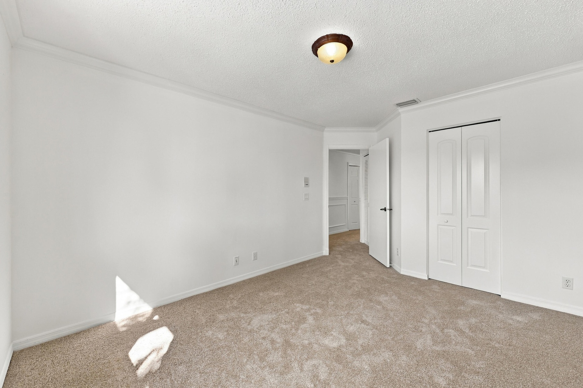 Generous proportions, soft carpeting, and a spacious closet make this bedroom ideal for guests, family members, or a home office.