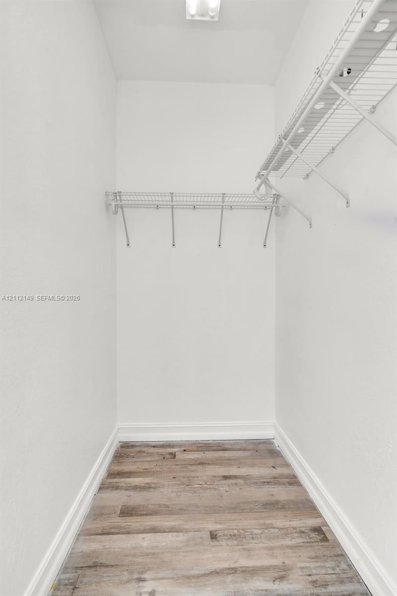 Storage space featuring wood-finish flooring and integrated wire shelving