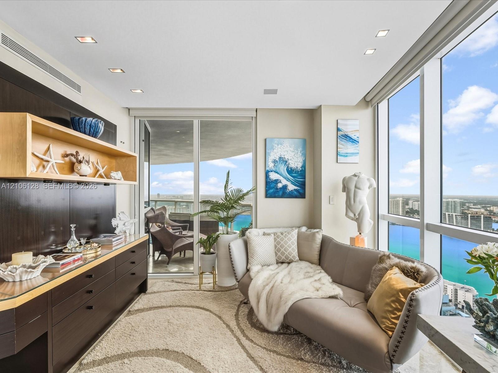 Floor-to-ceiling windows, built-in dark wood cabinetry with integrated open shelving, recessed lighting, and a private balcony