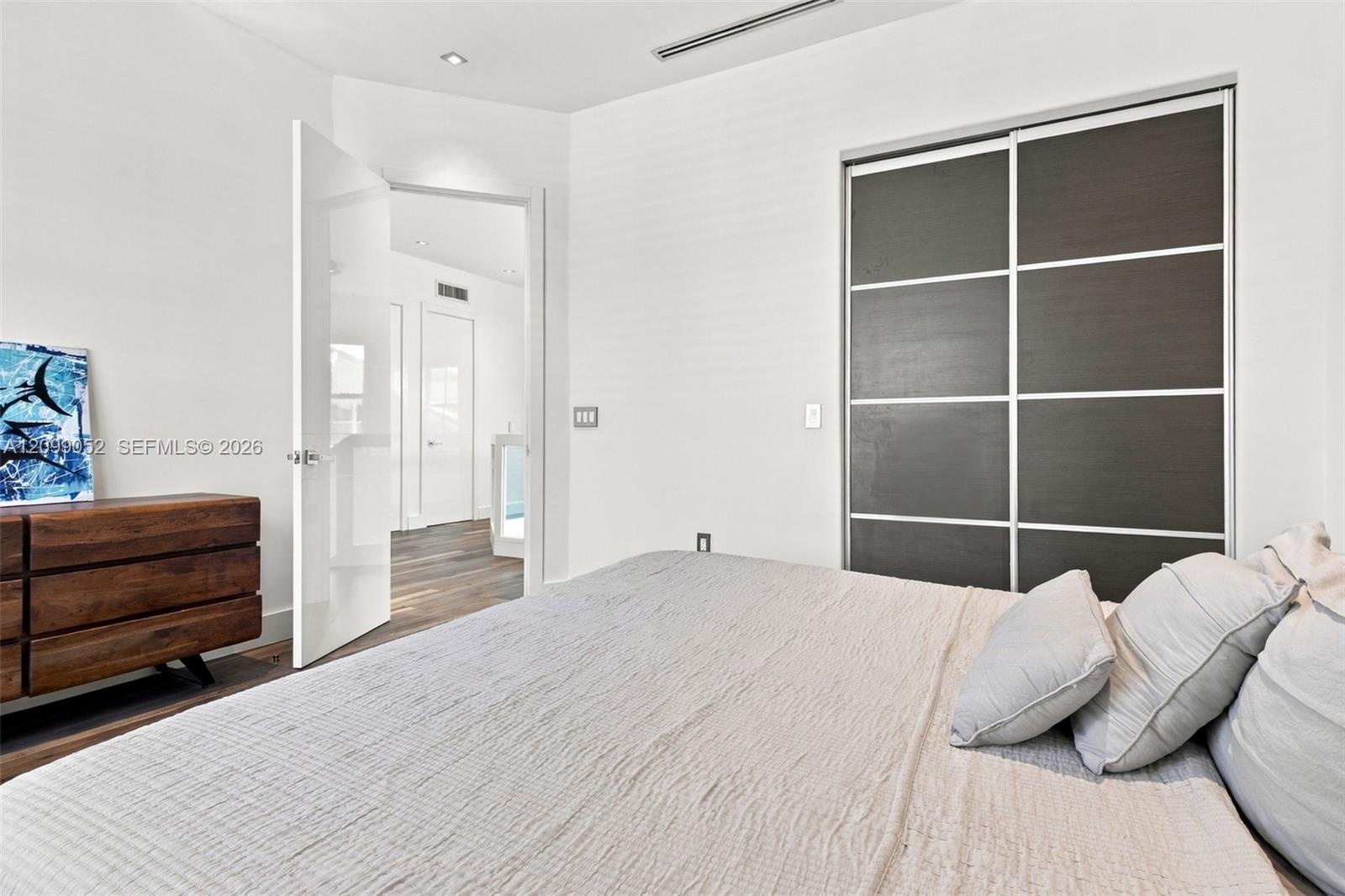 Sliding closet doors with dark wood-finish panels, recessed ceiling lighting, and crisp white walls