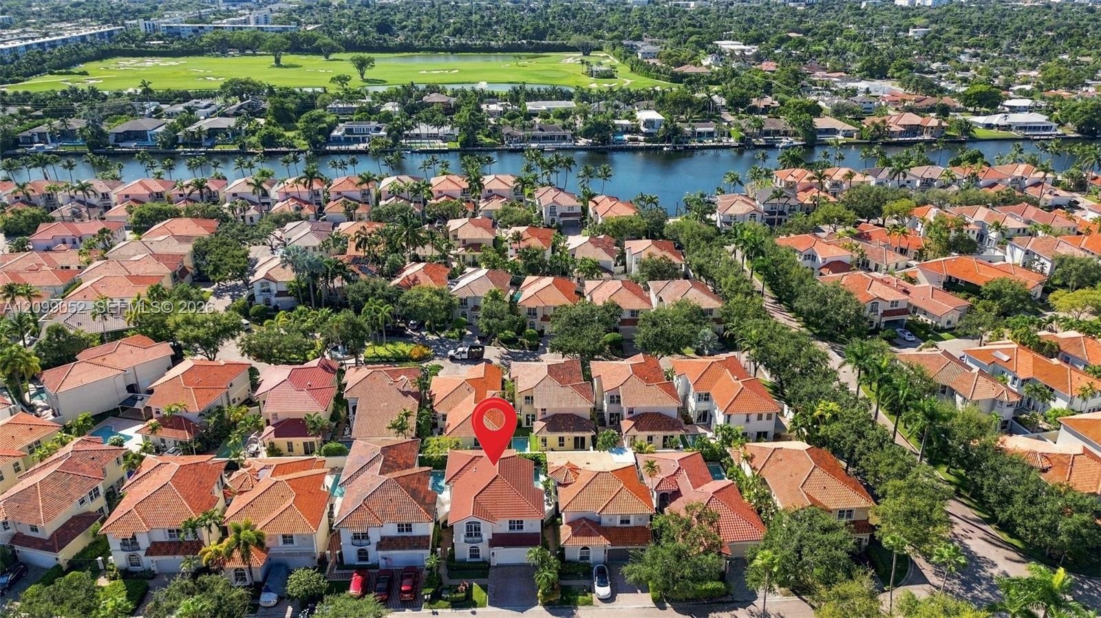 Aerial perspective featuring a two-story residence with a clay tile roof, private swimming pool, and concrete driveway