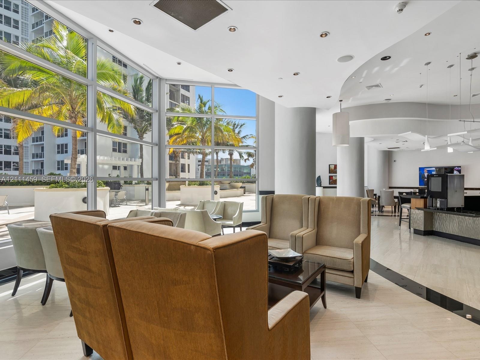 Floor-to-ceiling windows, recessed lighting, stone flooring, and built-in service counter