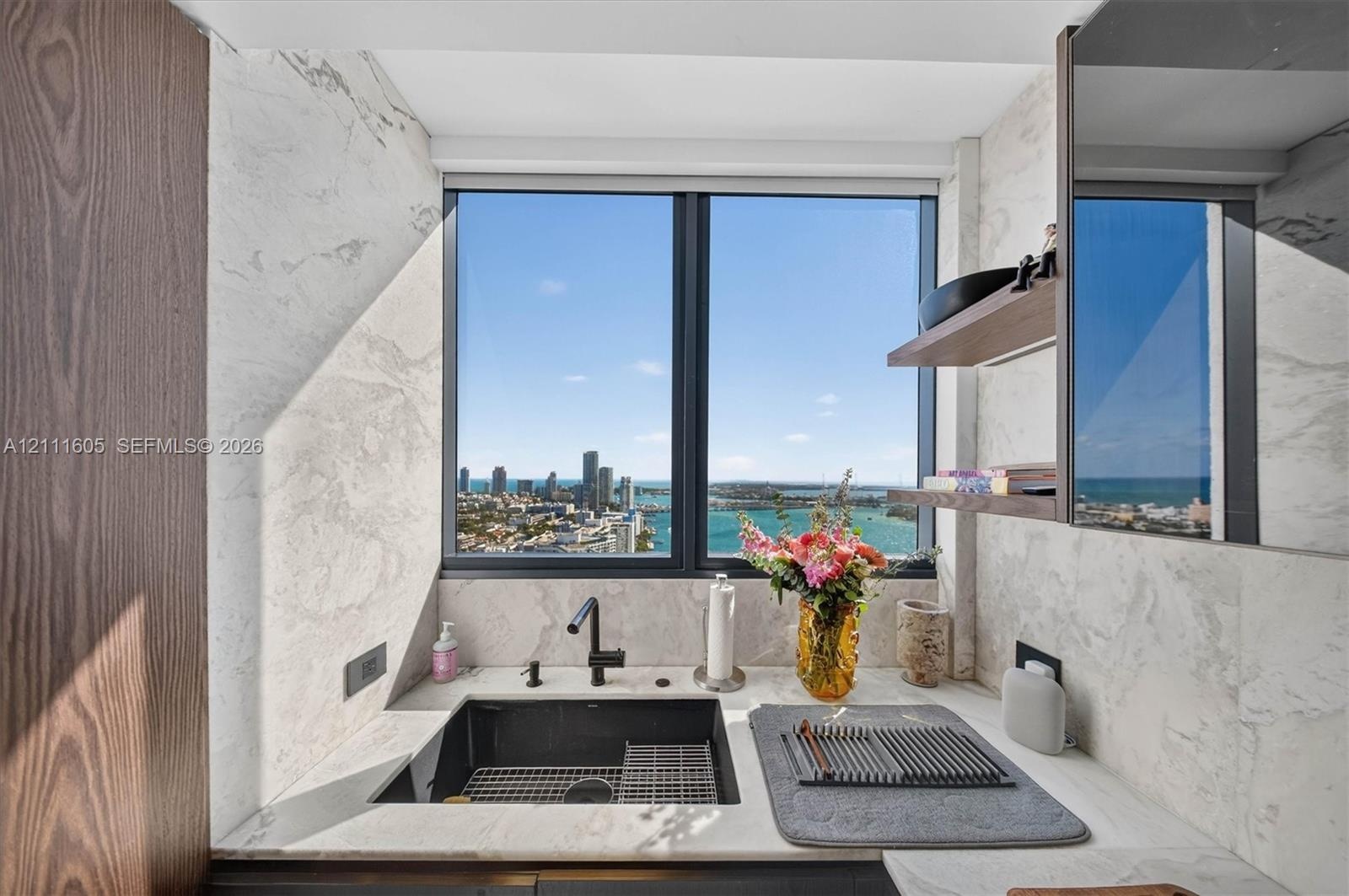 Private covered balcony featuring neutral tile flooring, a textured concrete ceiling, and a metallic horizontal-bar railing