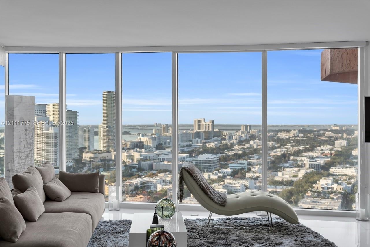 Floor-to-ceiling windows providing extensive city and water exposure, complemented by polished flooring